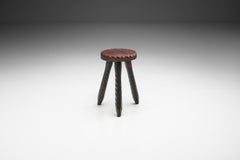 Tabouret tripode foncé sculpté, Europe, vers le milieu du 20e siècle