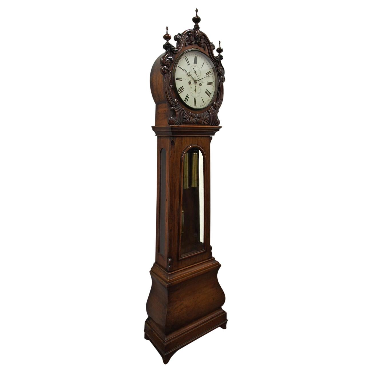 Exhibition quality carved drum head, glazed door grandfather clock by J. W. Mitchell of Glasgow, circa 1860. In the classic style of the period, the drum head is profusely carved with designs of C scrolls and flower heads, and the face has the