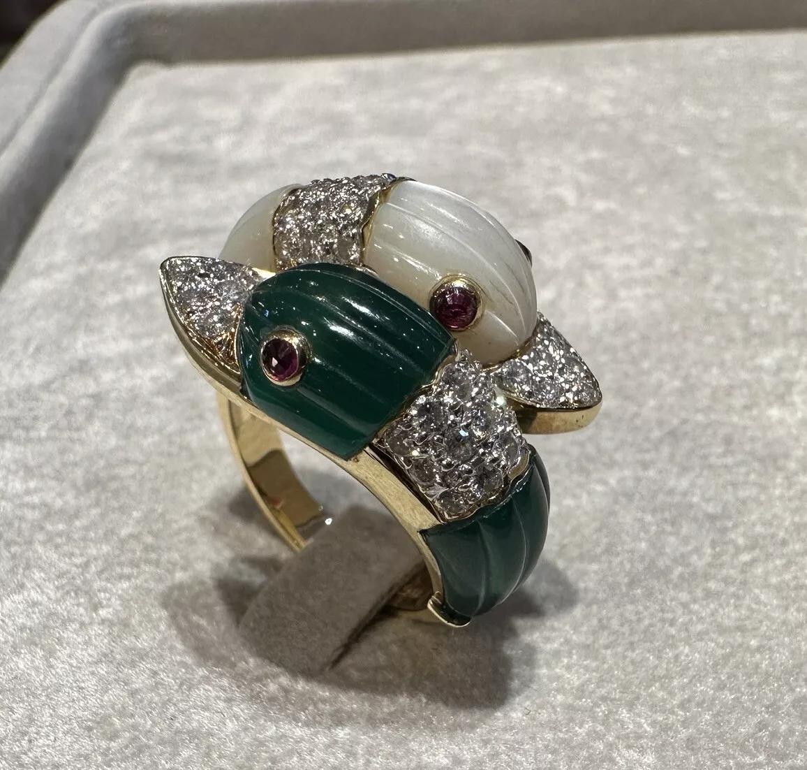 Carved Duck Heads Crossover Ring with Diamonds in 18k Yellow Gold

Estate Crossover Ring features Carved Mother of Pearl and Chrysoprase Duck Heads set with Round Brilliant Diamonds and Pink gemstone eyes, all set in 18k Yellow Gold.

Ring size is