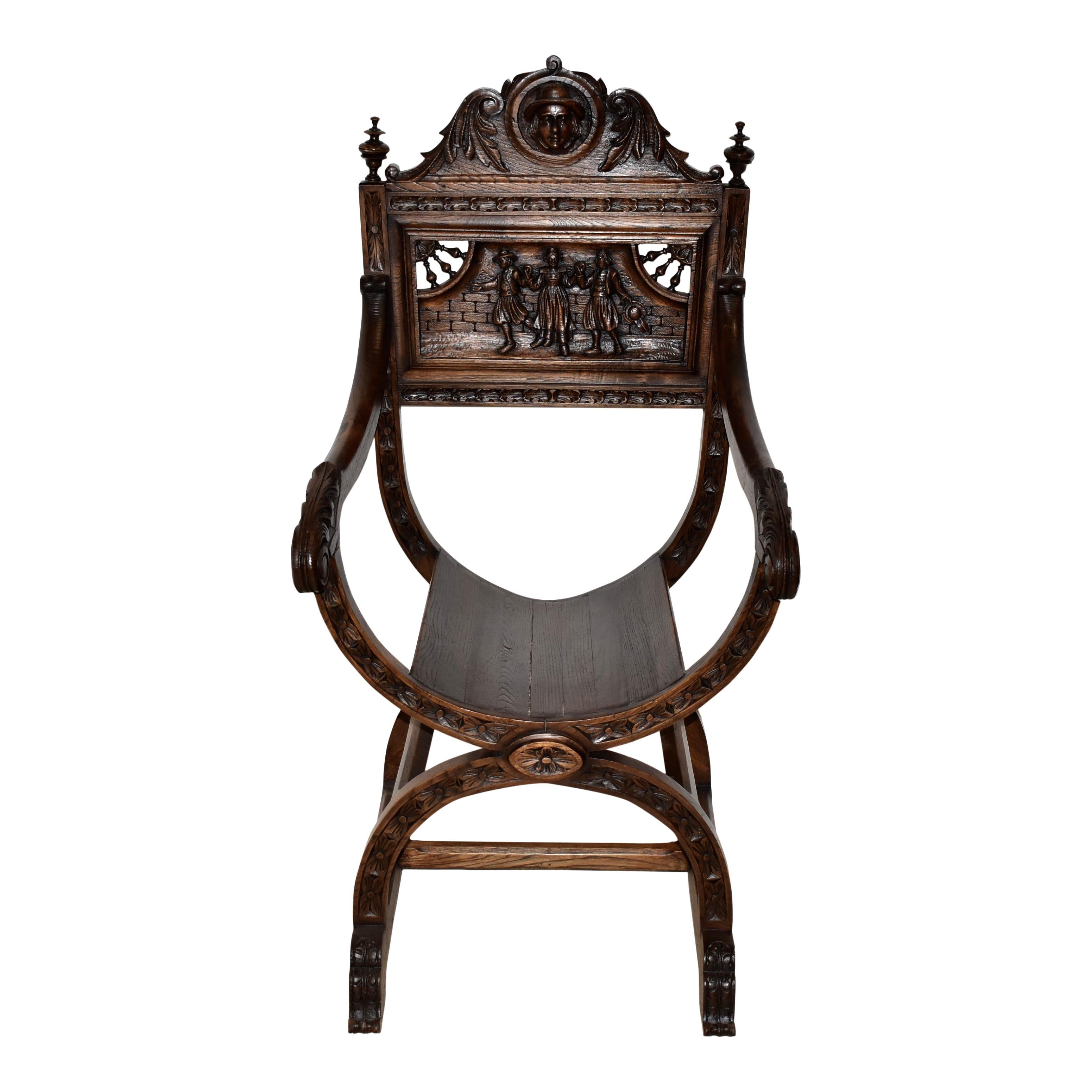 With a curule, throne like design and intricate Dutch carvings, this exquisite Dagobert style chair is a masterpiece. Crafted from oak and finished with a dark stain, the chair features a shaped cresting rail carved with a gentleman's face amid