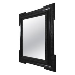 Carved ebonised wooden mirror, XIXth c.