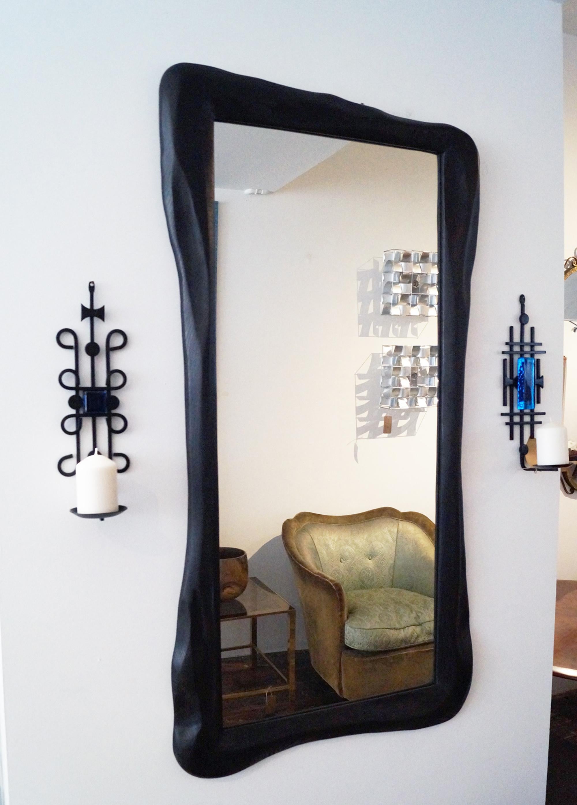A stunning hand-carved ebonized mirror, handcrafted by artist-designer John Alfredo Harris. One-off piece. 
John Alfredo Harris's has been exhibited in various well-known galleries in Europe. All work is handcrafted and designed in his Studio in