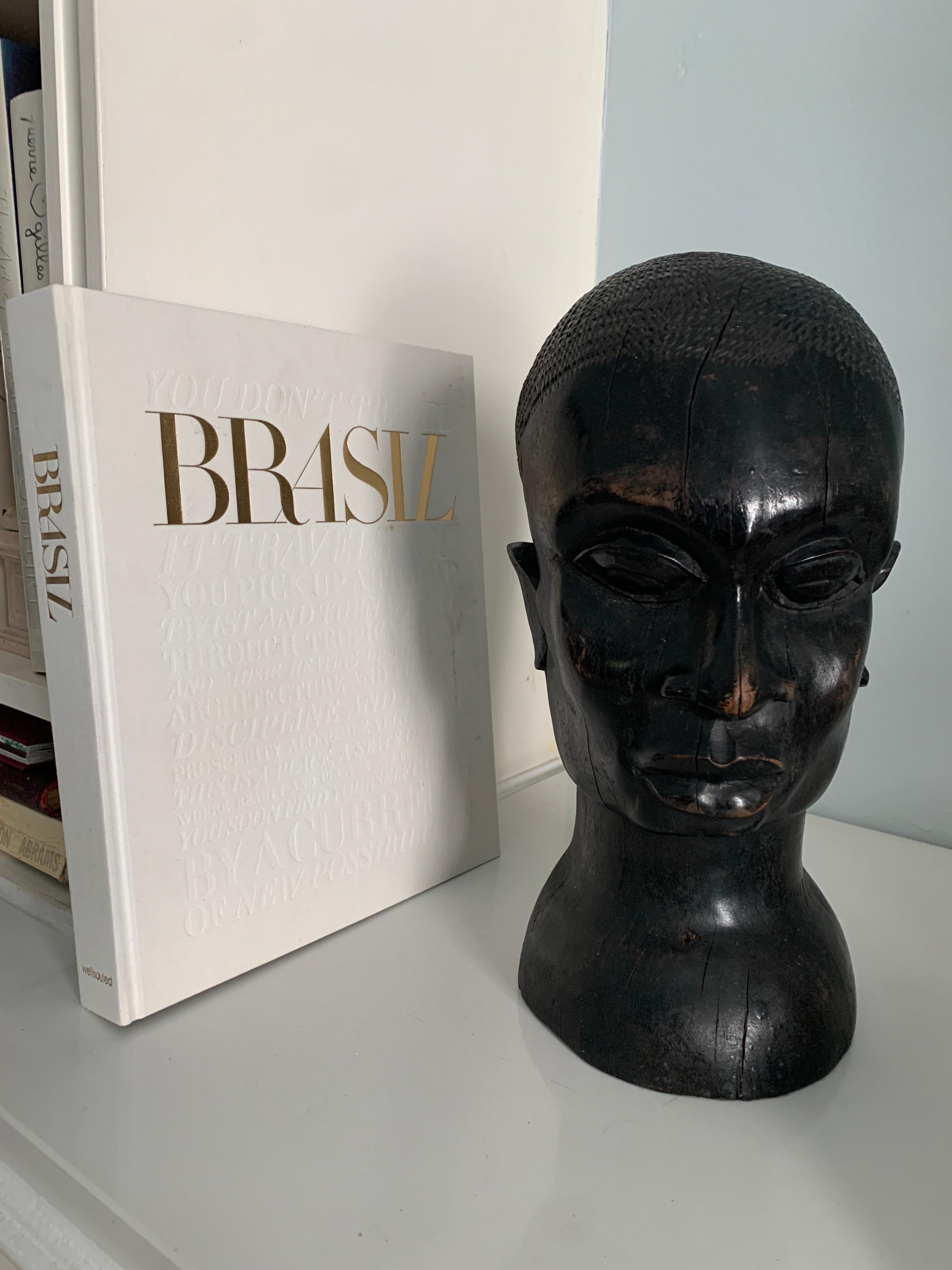 A wonderful hand carved head of Hardwood. A stunning sculpted and carved piece. A stand alone decorative piece or can be used as a large book end. Truly a compliment to any space and especially those with ethnic tones... a beautifully made face.