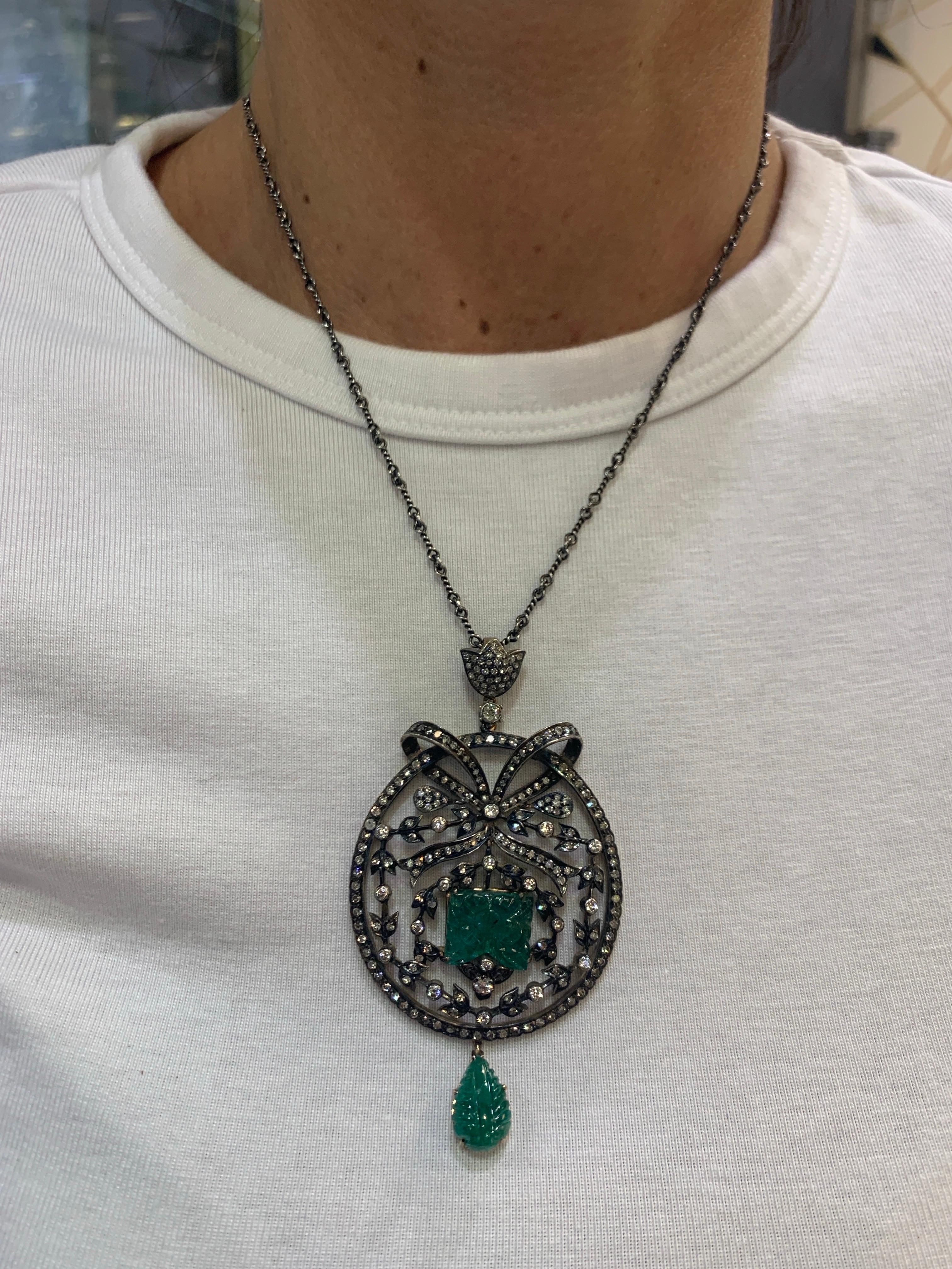 Collana con smeraldo intagliato e diamanti

Un ciondolo rotondo con un fiocco nella parte superiore e una goccia di smeraldo intagliato nella parte inferiore. Al centro si trova uno smeraldo intagliato circondato da un motivo a vite ornato da