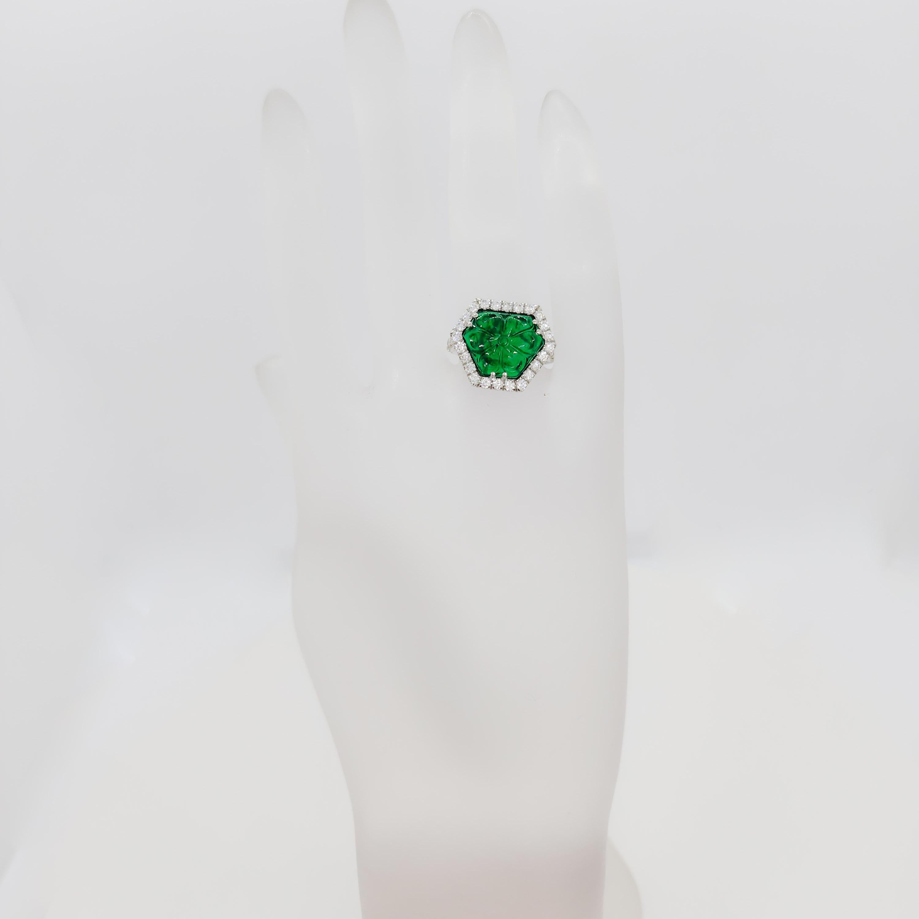 Beautiful 5.69 ct. carved emerald fancy shape stone with 0.95 ct. good quality white diamond rounds.  Handmade in platinum.  Ring size 6.75.