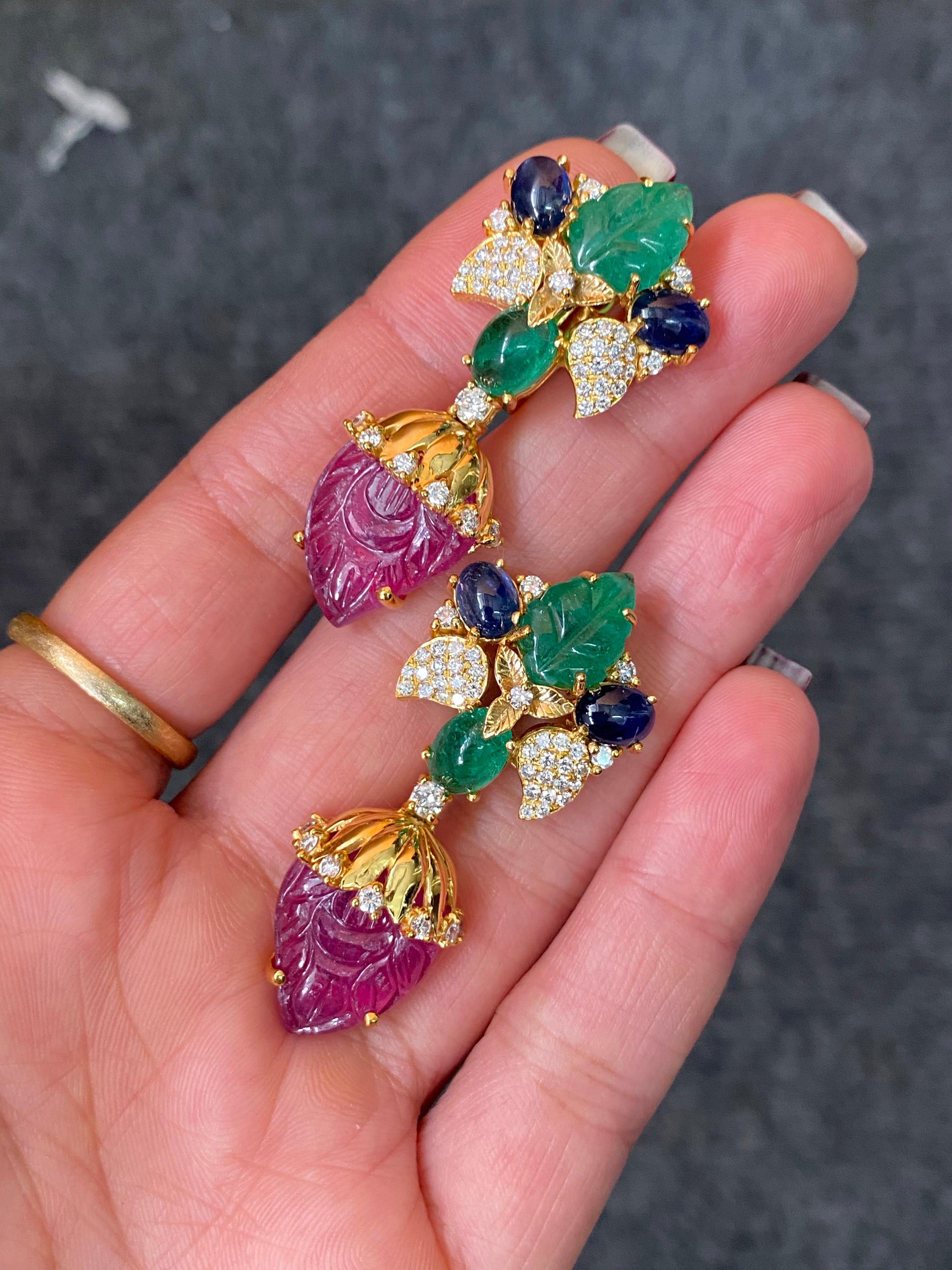 A pair of beautiful Art-Deco looking earrings, with 26.14 carat carved Rubies, 4.59 carat Sapphire, 8.85 carat Emerald and 1.49 carat White Diamonds all set in 17.42 grams of solid 18K Yellow Gold. The earring comes with omega backing, for extra