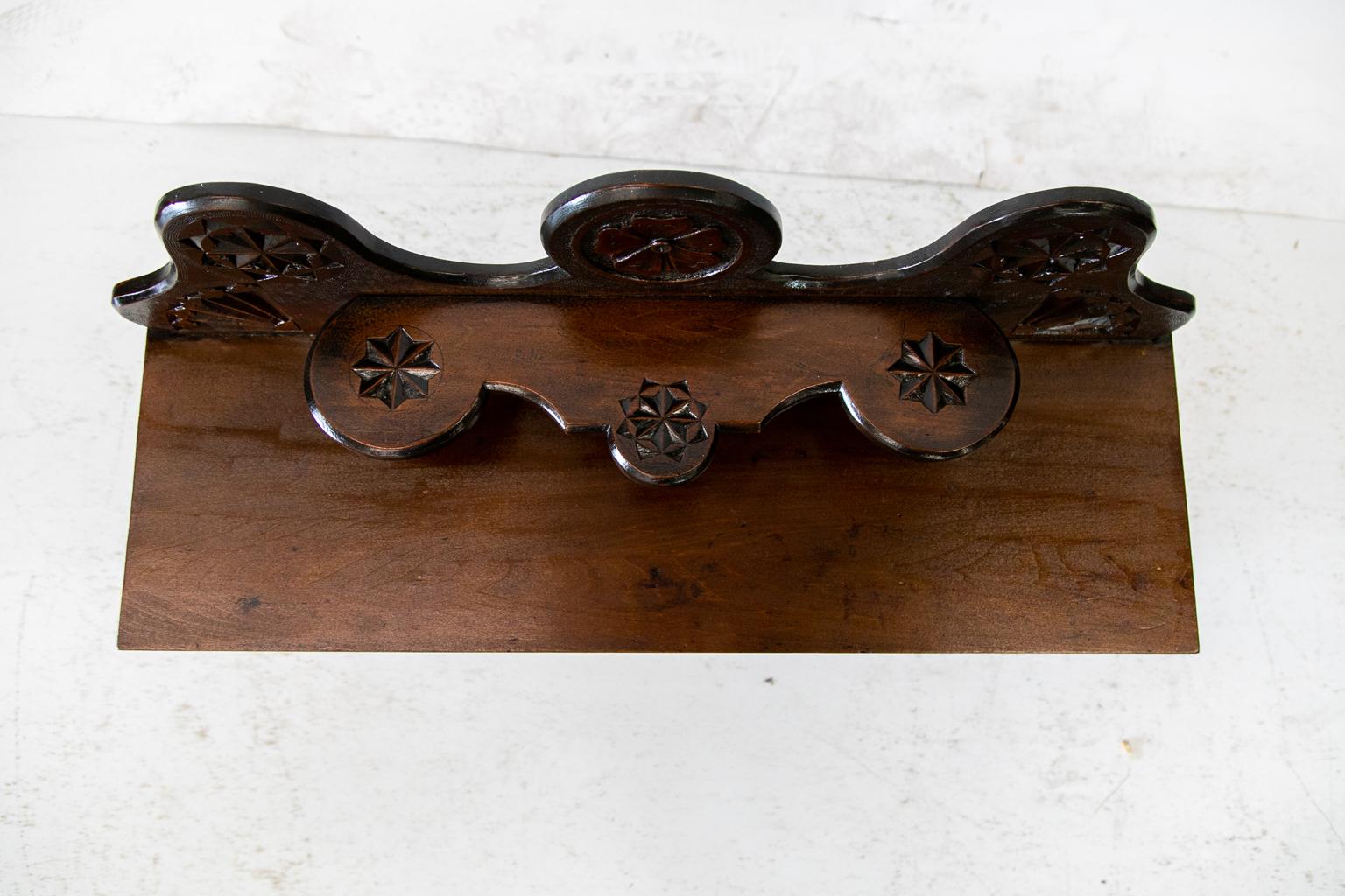 Carved English hanging shelf, the door has a floral center panel framed with carved moldings, stippling, and stylized quarter fans. The inside has one shelf with a center drawer and matching side panels. The side shelves are supported by turned