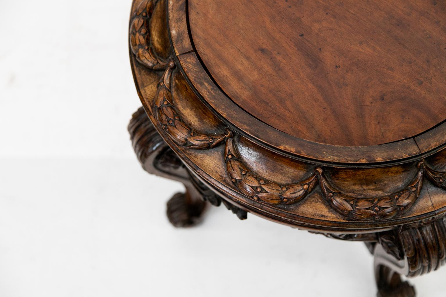 Carved English jardinière stand, this stand has a convex upper frieze with floral swags. The lower frieze is fluted with floral carvings. The four cabriole legs with acanthus carved knees and carved French scrolled feet.; carved cross stretcher with