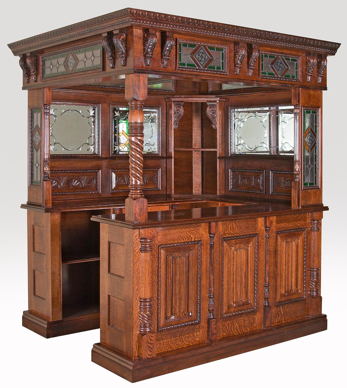 A carved English oak corner bar with linen fold panels below and a stained glass panel in the ceiling and hand etched mirrors. This is a superbly handcrafted reproduction of a small pub found in the English countryside.
Measures: Height 91