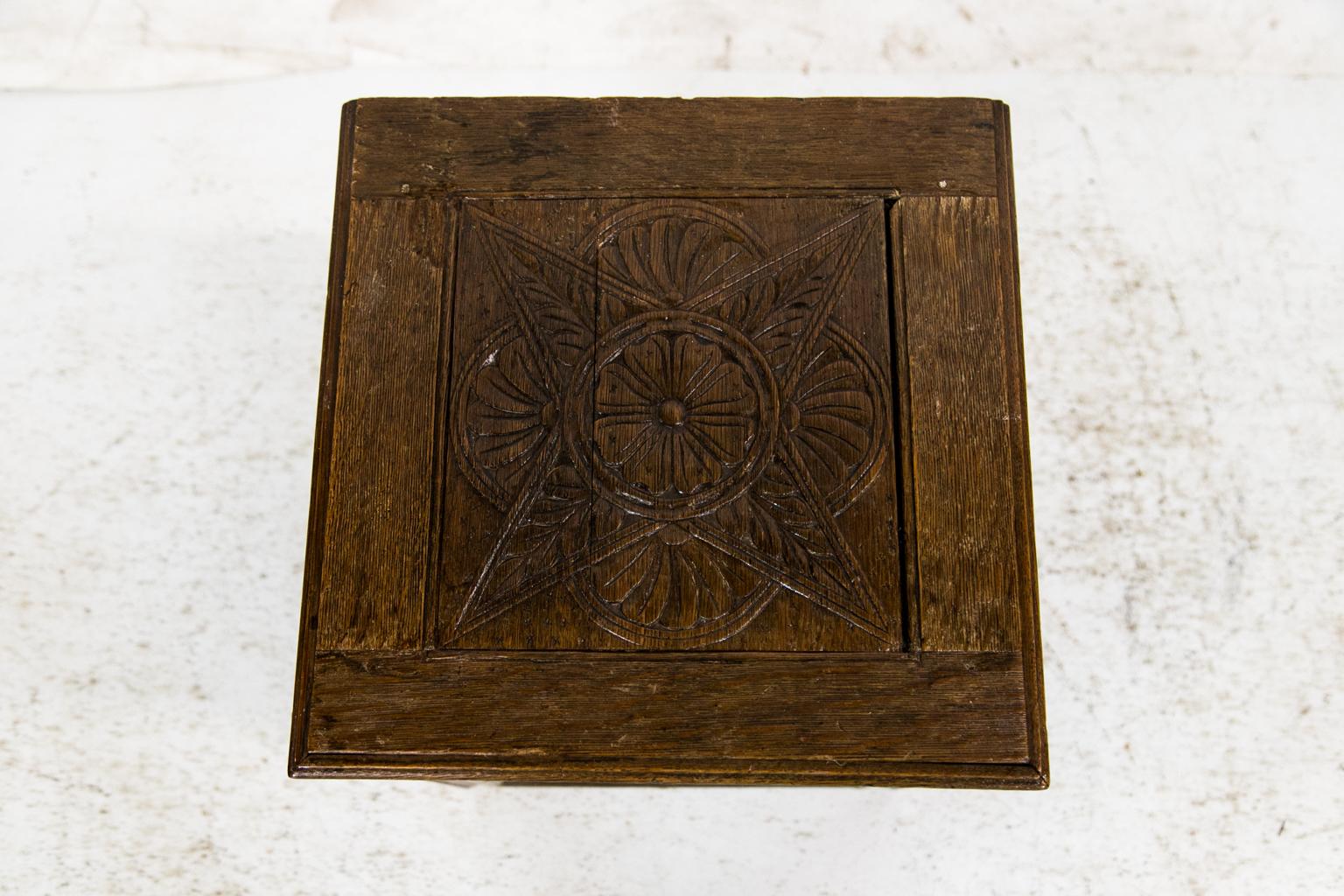 This carved English oak hearth box is carved on the top and three sides with Jacobean styled panels. The interior steel hinges are original and have the name “Baldwin” cast into the steel. The back has a recessed panel.
  