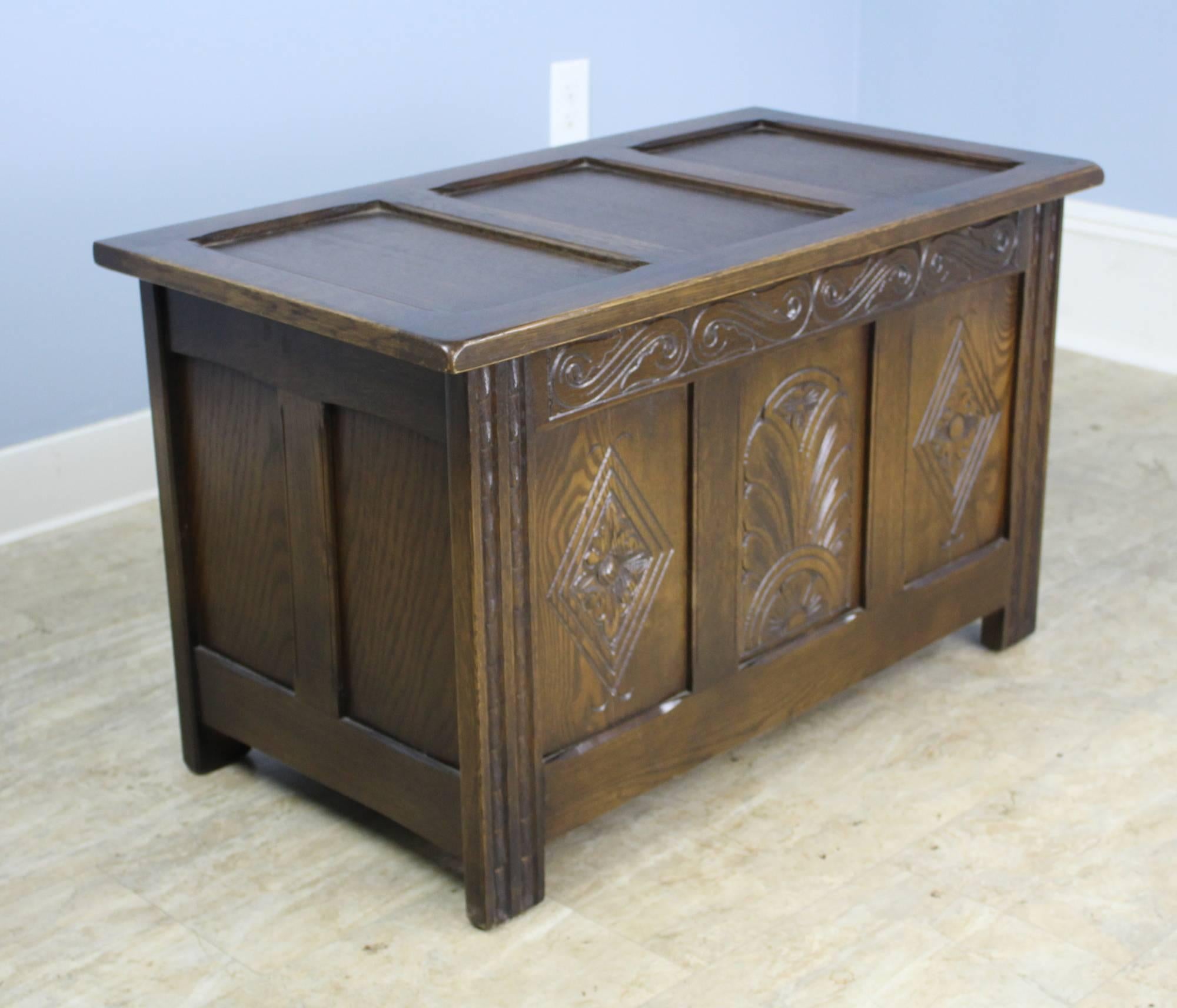 A small three-panel oak box with stylized carvings on the front. Excellent small storage and very clean inside.