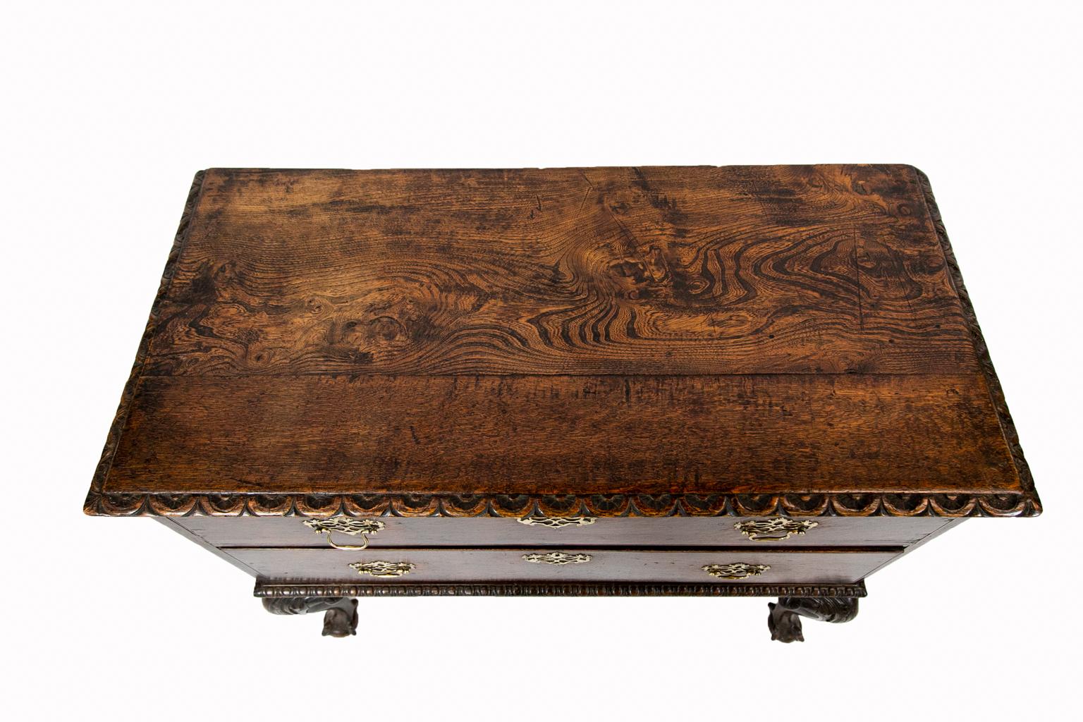 Carved English oak two-drawer chest on legs has carved top molding while the base has egg and dart molding on acanthus carved cabriole legs, which terminate in ball and claw feet. There is exceptionally nice trellis work hardware.
 