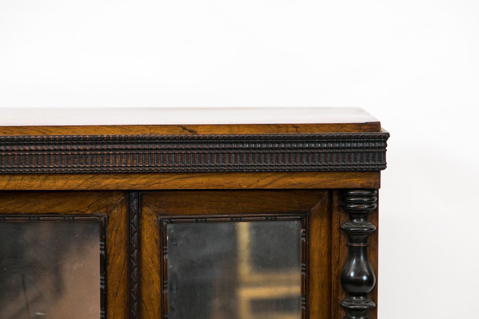 Carved English rosewood miniature cabinet, carved applied moldings surround the mirrors, drawer, and base molding. The applied front stiles have applied turnings and the inside has four shelves.
 
