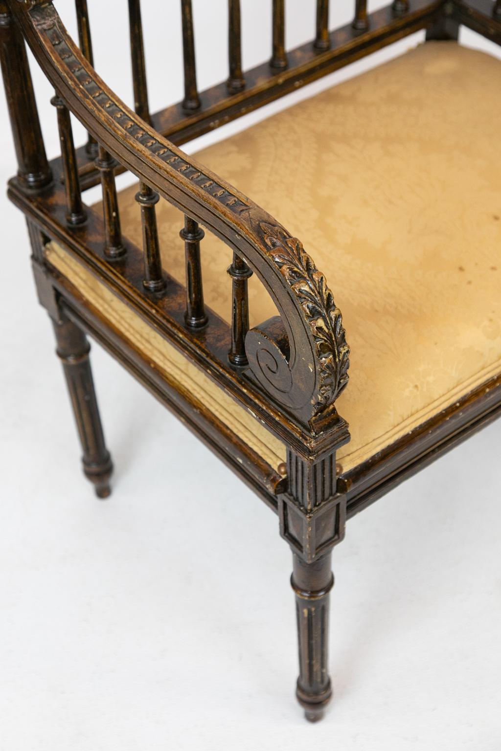 Carved faux painted French stool, has fluted spindles and acanthus carved arms with a folded ribbon reticulated crest. The legs are fluted and terminate in elongated onion feet.
The damask fabric has some staining.
 