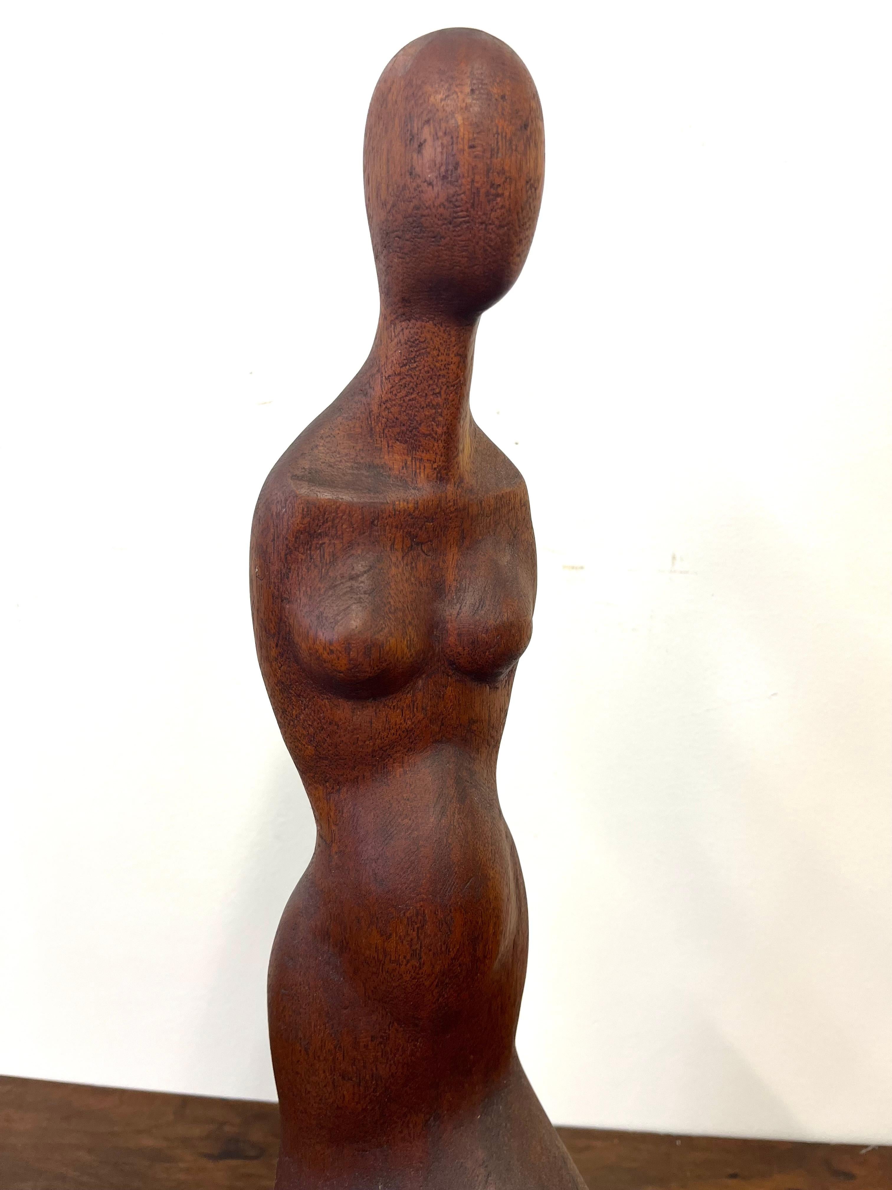 Escultura de figura femenina tallada en madera de teca, circa 1960 Estadounidense