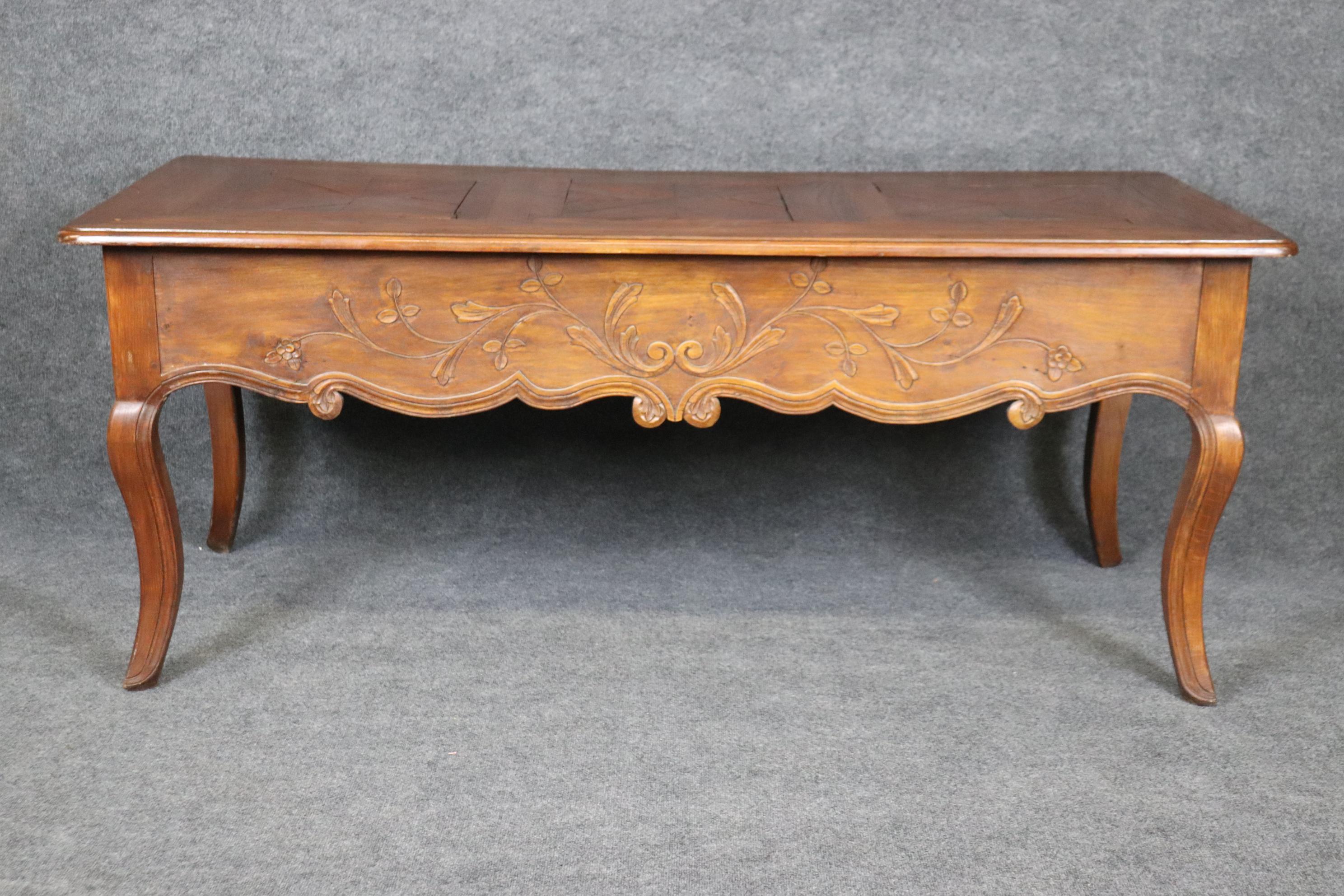 This is a rare form of Country French desk. The desk features what appears to be oak and walnut construction and a parquet top with antique age cracks in the top. WE CAN REPAIR THIS but a purist will probably want this left alone so you must let use