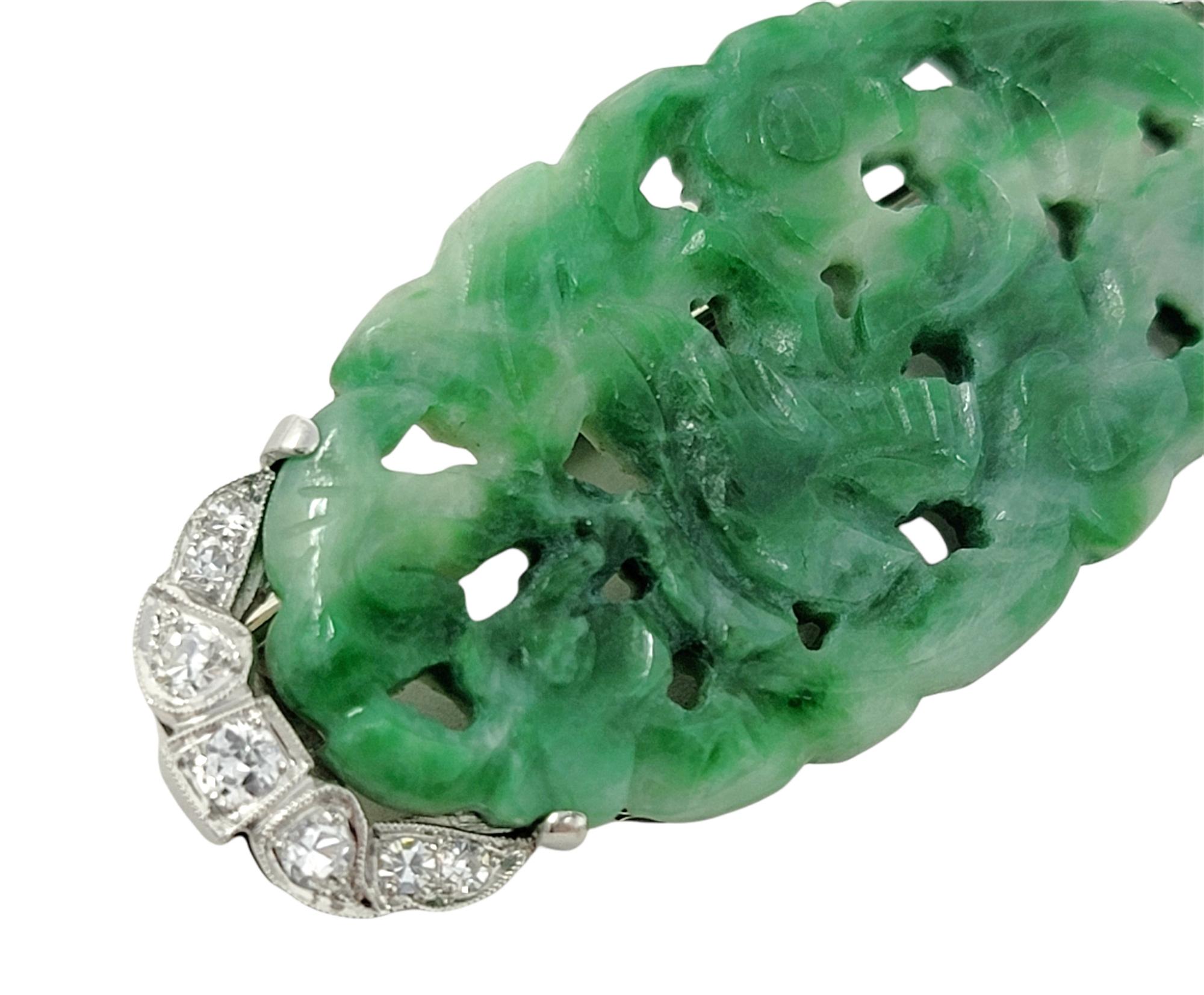 Gorgeous, intricately carved jadeite brooch with dazzling diamond accents offers bold color, unique style and undeniable glamour.

Metal: 14K White Gold
Weight: 8.5 grams
Natural Diamonds: .27 carat total weight
Diamond cuts: Round and