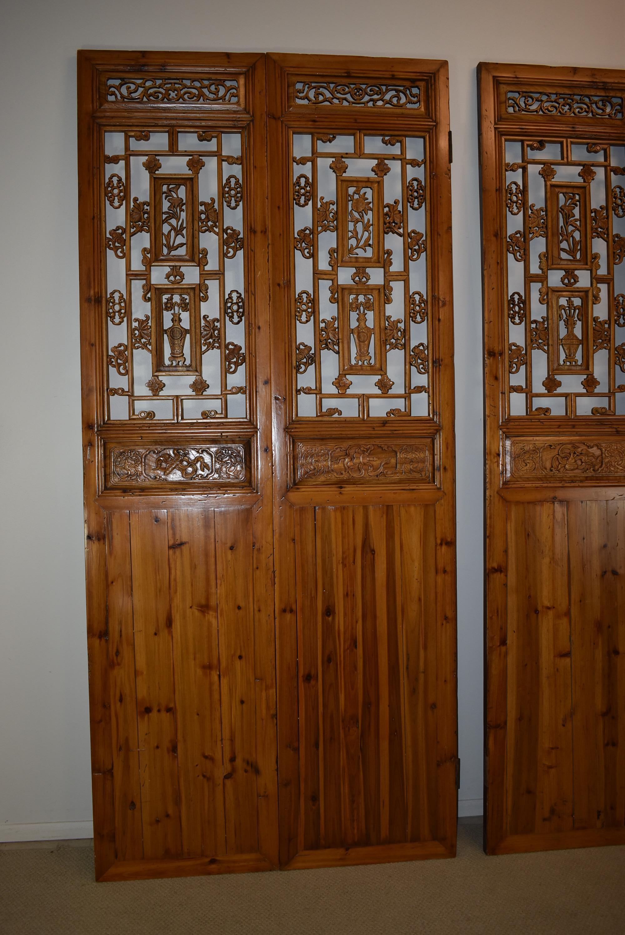 Carved Asian Style wood screen depicting dragons, flowers and vases. Each set consists of 4 panels, 2 pairs as pictured, measuring 46 7/8