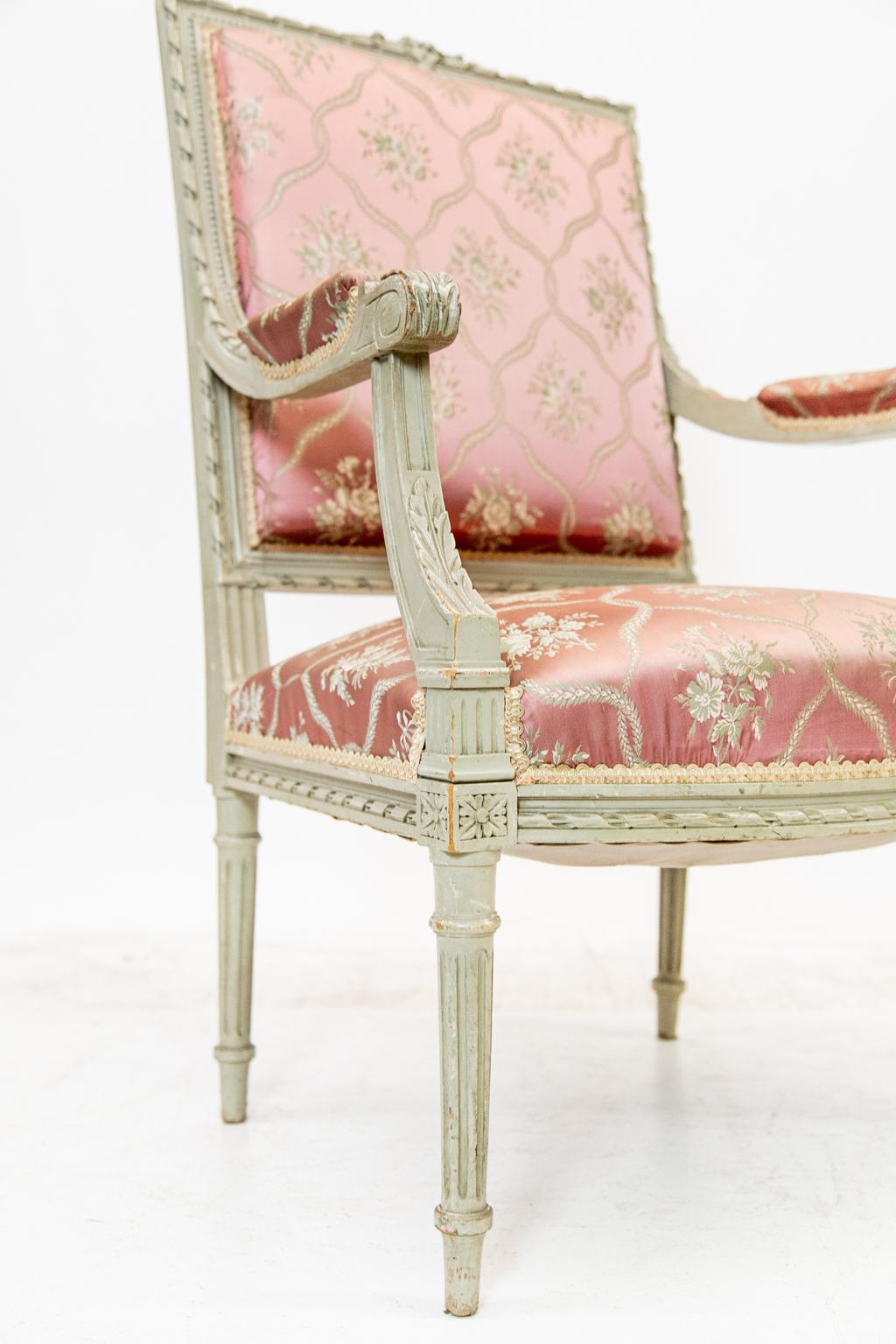 Carved French fruitwood painted armchair, arms with carved acanthus leaves. The stiles and top rail are carved with spiral edges and have a floral crest. There is carved beadwork surrounding the back. Spiral ribbon carving borders the seat bottom