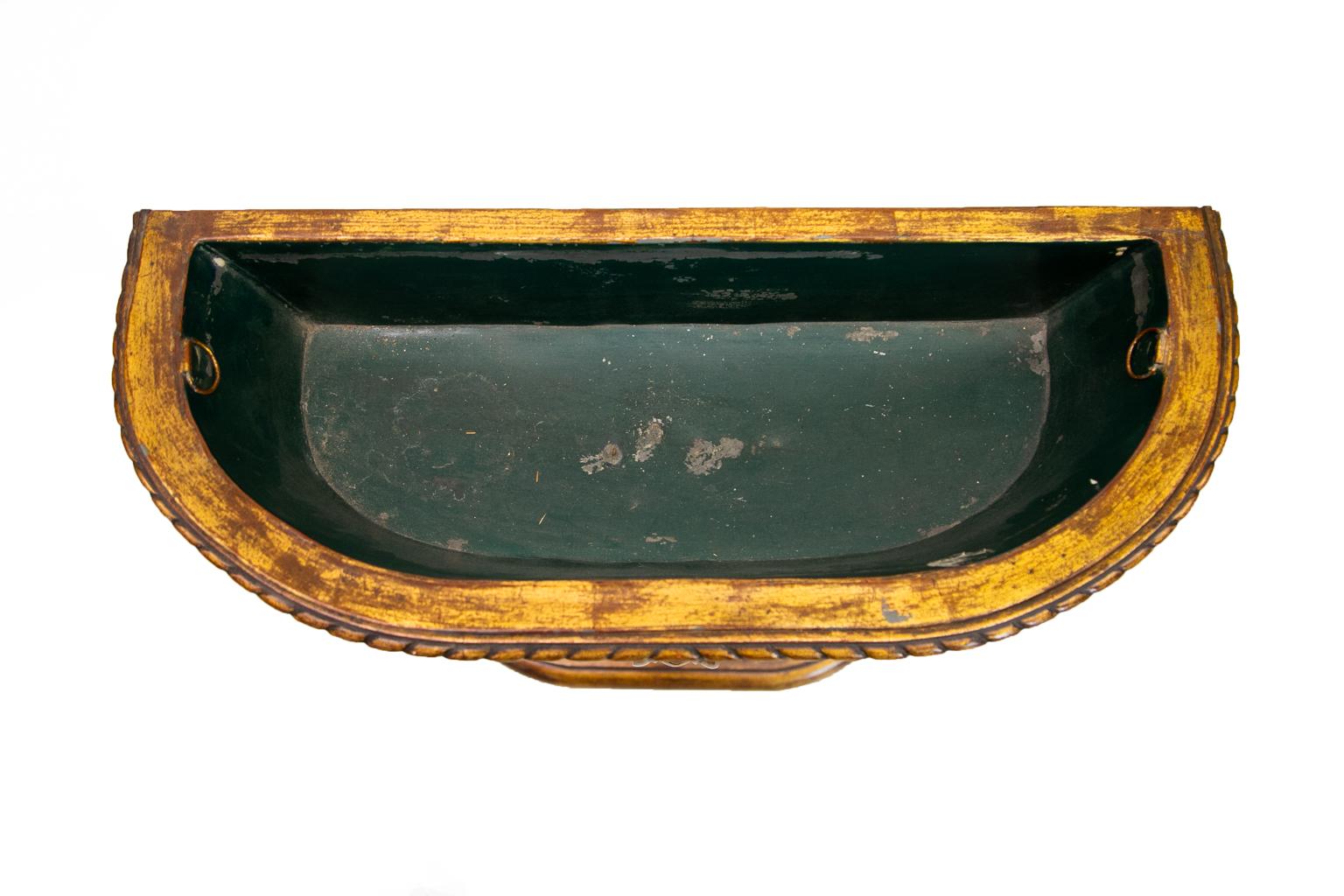 This carved French gold planter has a removable tin liner. The top edge has carved gadrooned edging on the top and a beaded molding on the bottom. The center of the container portion has a carved quilted pattern. The three legs have scroll shapes