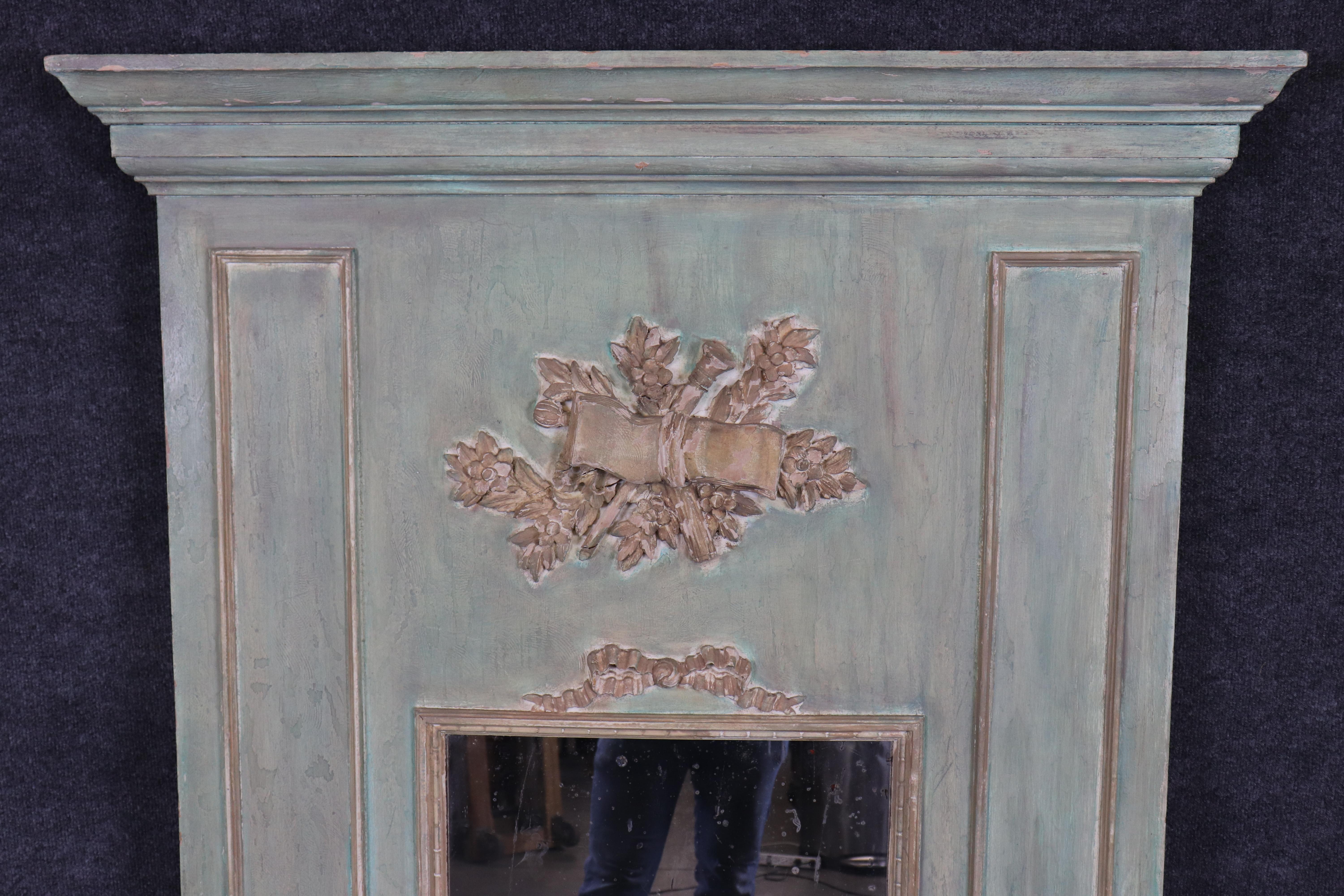 This is a gorgeous French blue-green colored antique trumeau mirror with wonderful patinated glass which shows its age and has charm and defects some people absolutely love. The mirror has signs of age and use on the frame too. The carving is simple