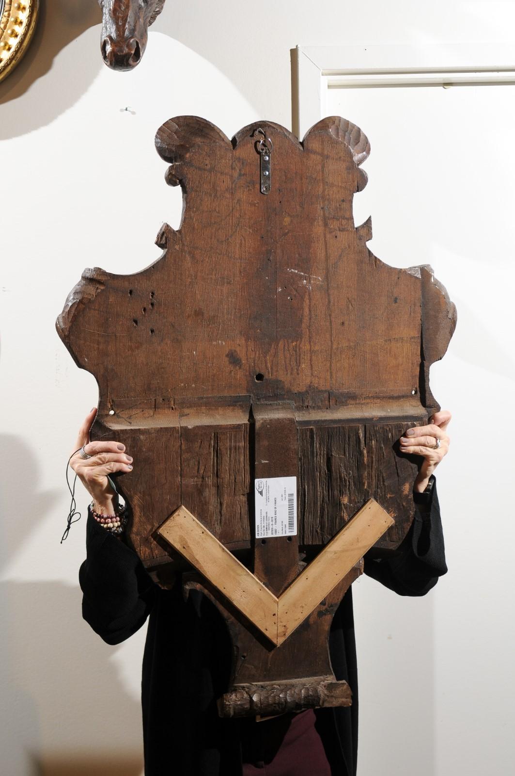 A French 19th century hand-carved wooden cartouche depicting the House of Rothschild coat of arms representing an embowed arm grasping five arrows. This large decorative wall panel features the coat of arms of the Rothschild family, who established