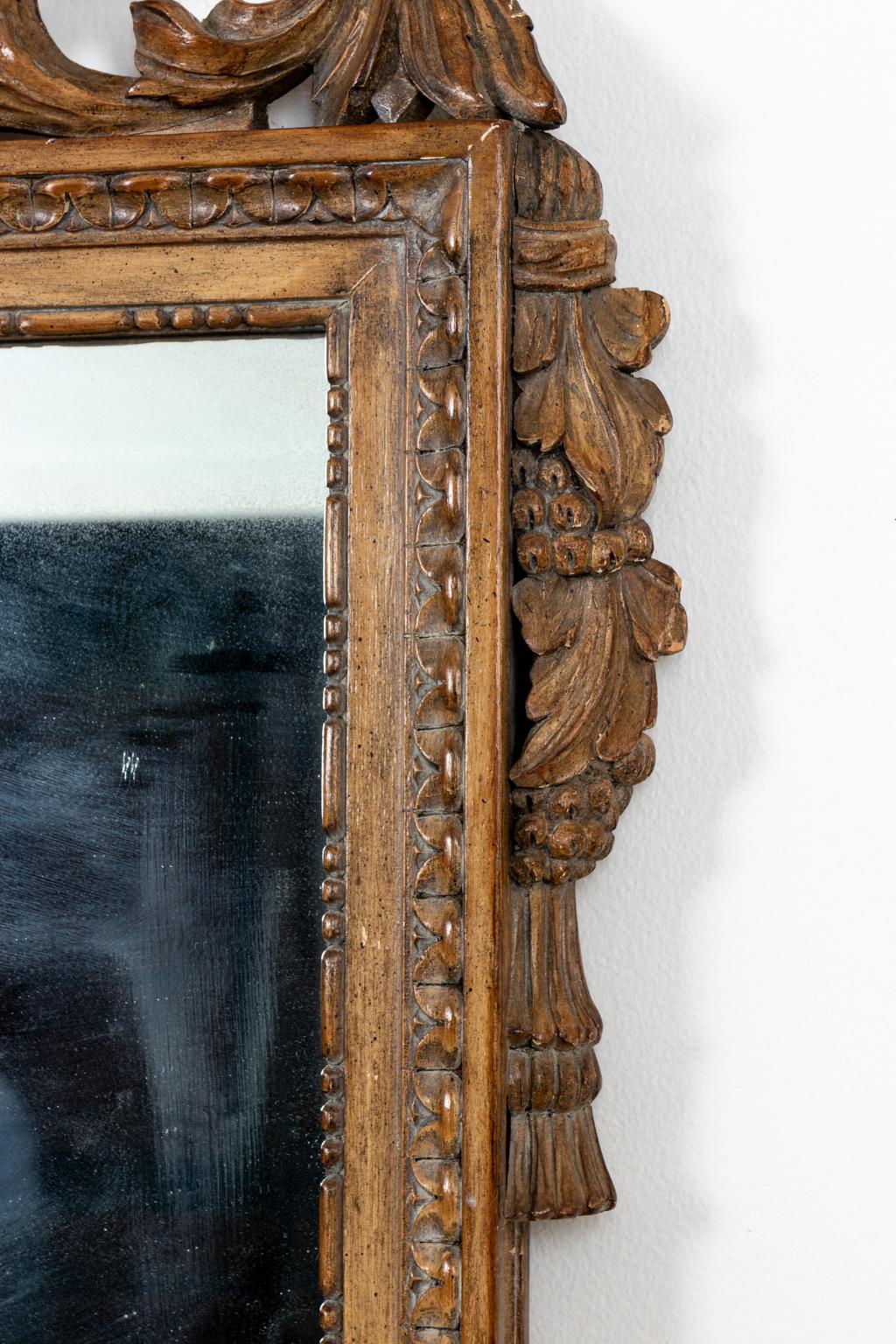 Circa 1960s carved French mirror in the style of Louis XVI. Please note of wear consistent with age.