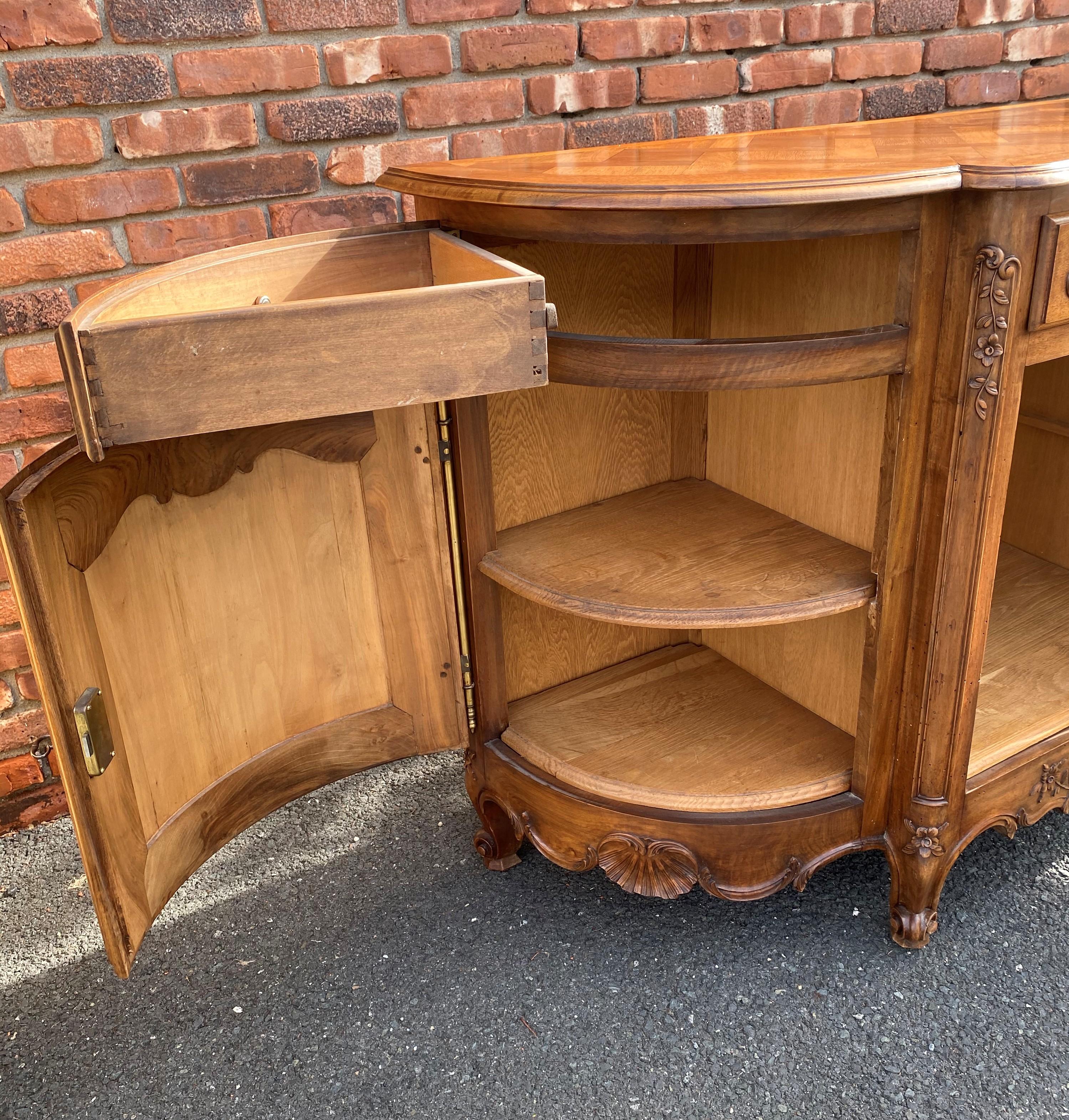 Beautiful hand carved solid French oak buffet. The sides are unusual as they are curved along with the side doors and side drawers. From the Brittany region of France This piece has lots of storage with 3 separate removable shelves (one in each