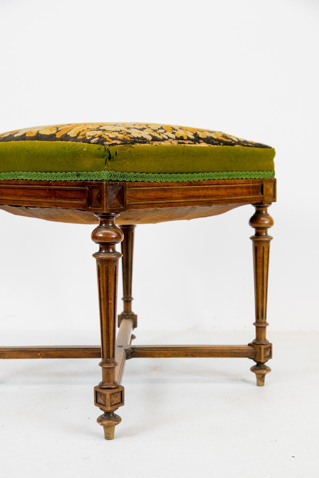 Carved French walnut needlework stool, needlework seat featuring birds and flower, turned and fluted legs supported by ''X'' stretcher. Note that there is wear to the needlework on the edges, (see photos).
  
