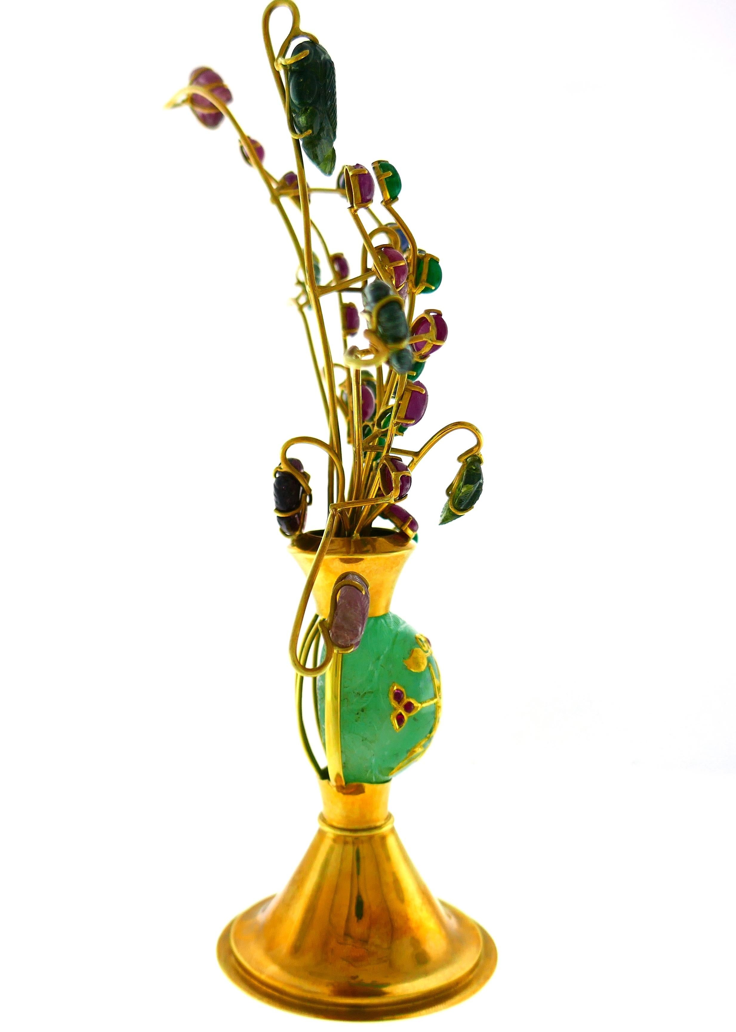 Exquisite desk accessory designed as a floor vase with a flower bouquet. It is made of 18 karat (stamped) yellow gold and carved and cabochon emerald, ruby, sapphire and green tourmaline.
Tastefully made, the piece is very pleasing to the