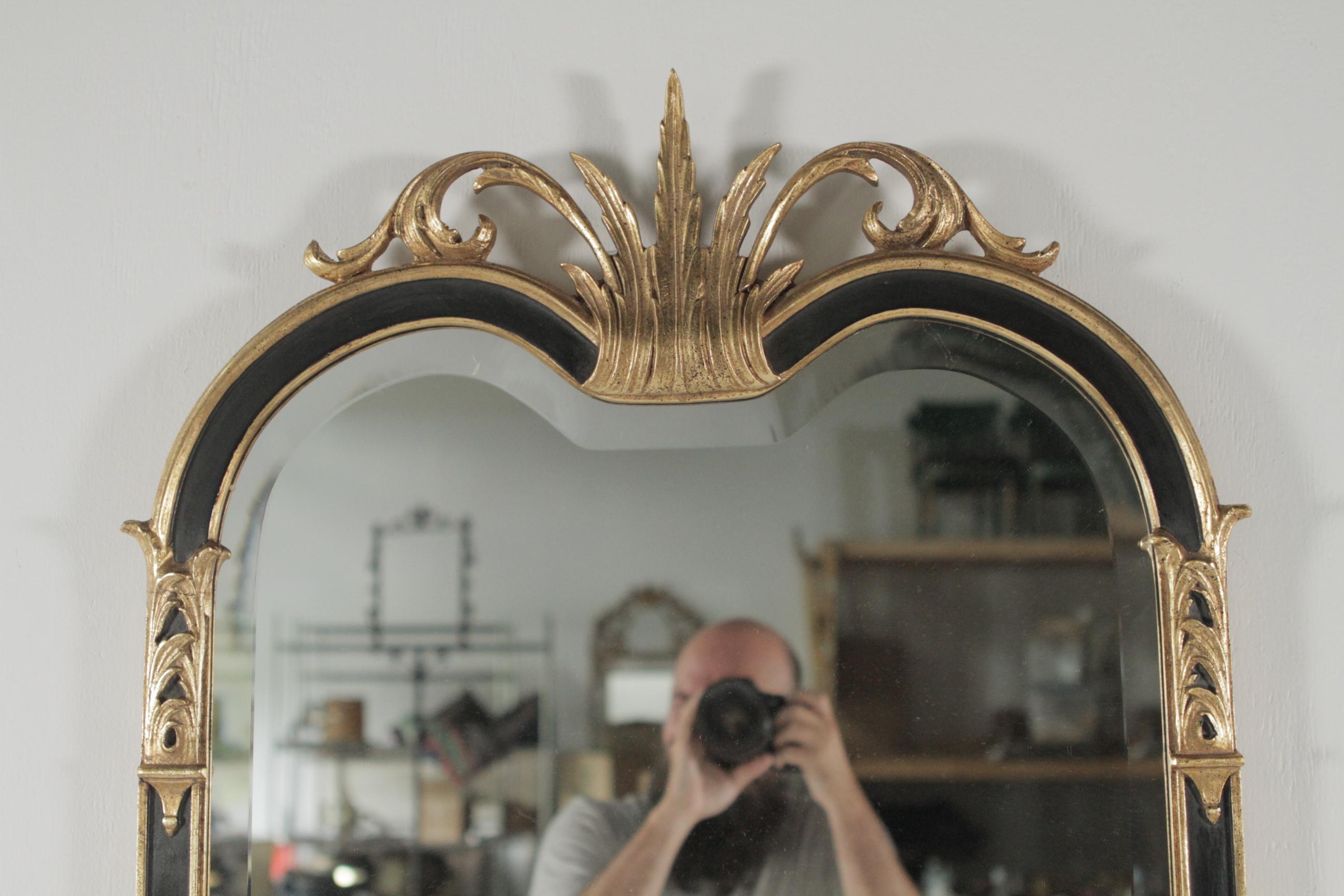 A carved gilt and painted mirror by Friedman. Dimensions 39” L x 26” W x 1.25 D.