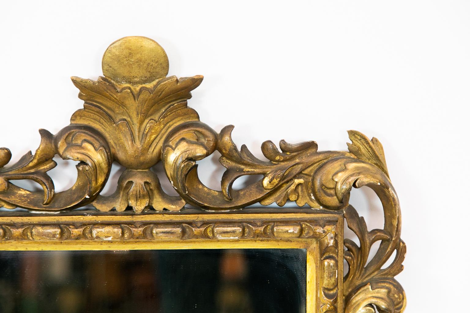 Carved gilt French mirror is carved with floral arabesques and repeating egg and dart molding.