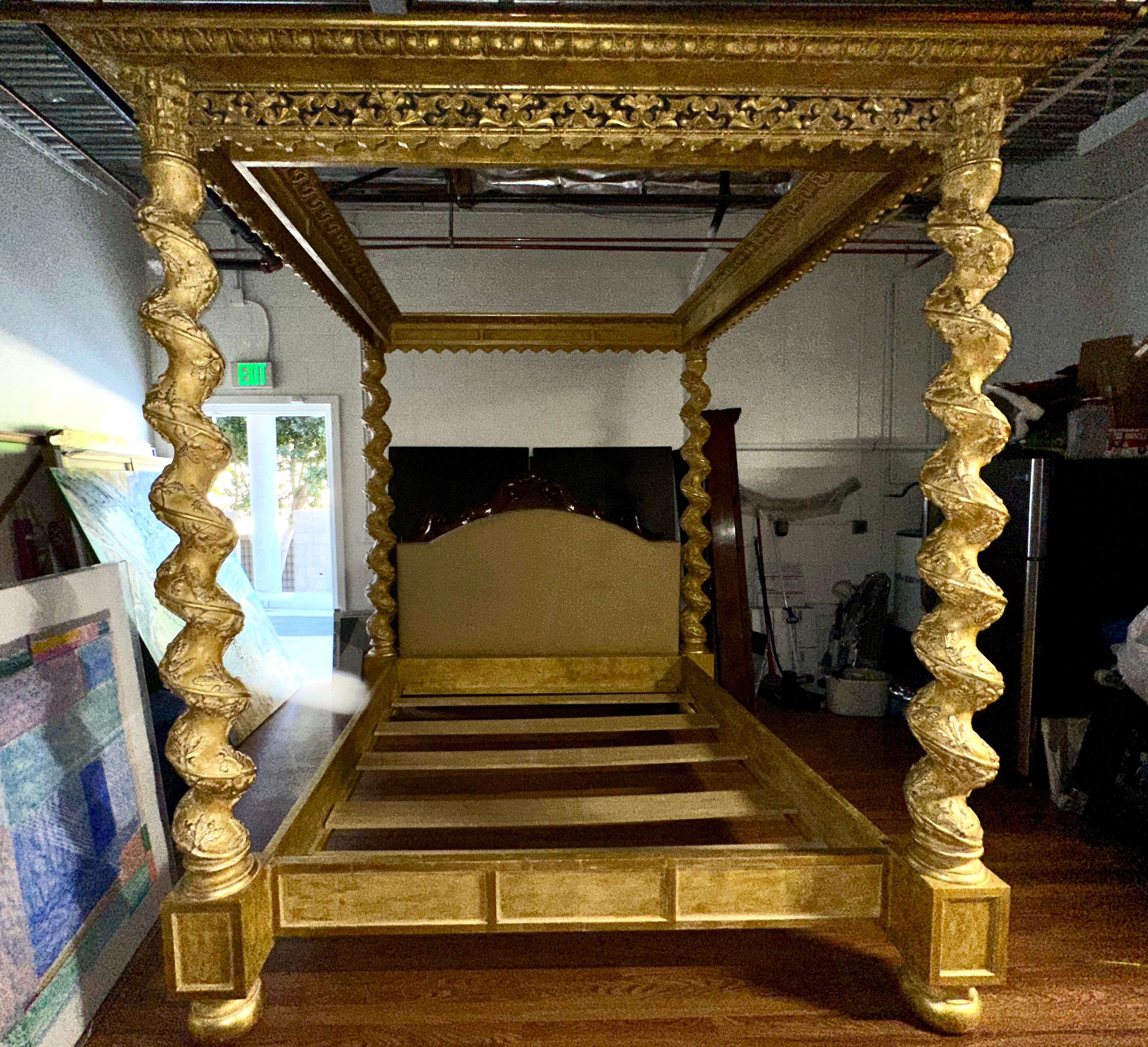 A magnificent Carved gilt Italian style 4 poster canopied bed. It features 4 twisted columns on the corners and an upholstered headboard. The interior dimensions are slightly over 72x84 inches which is a California King size. The bed was in a