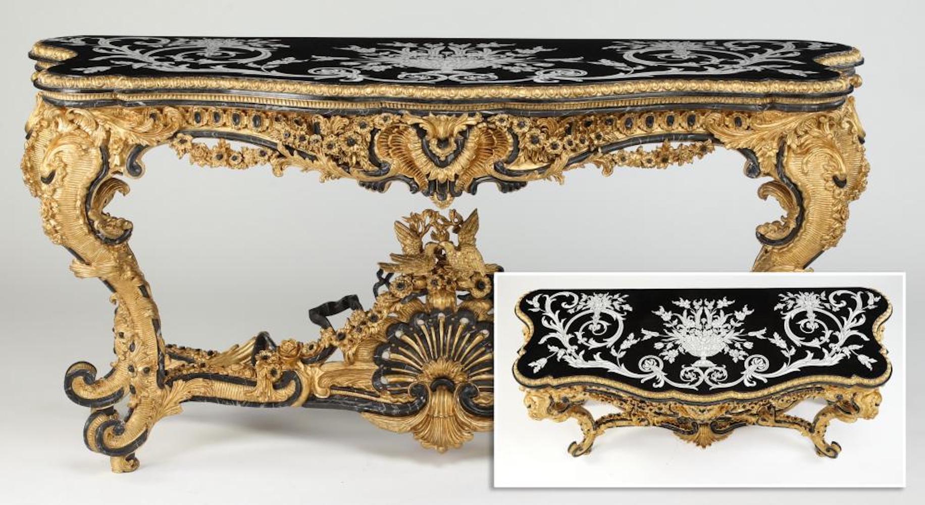 Elaborately carved and gilded Italian console in the Rococo taste, the shaped black marble top centering an inlay of a flower-filled urn flanked by rocaille scrollwork and trailing blossoms, above the gilded and paint decorated apron centering a