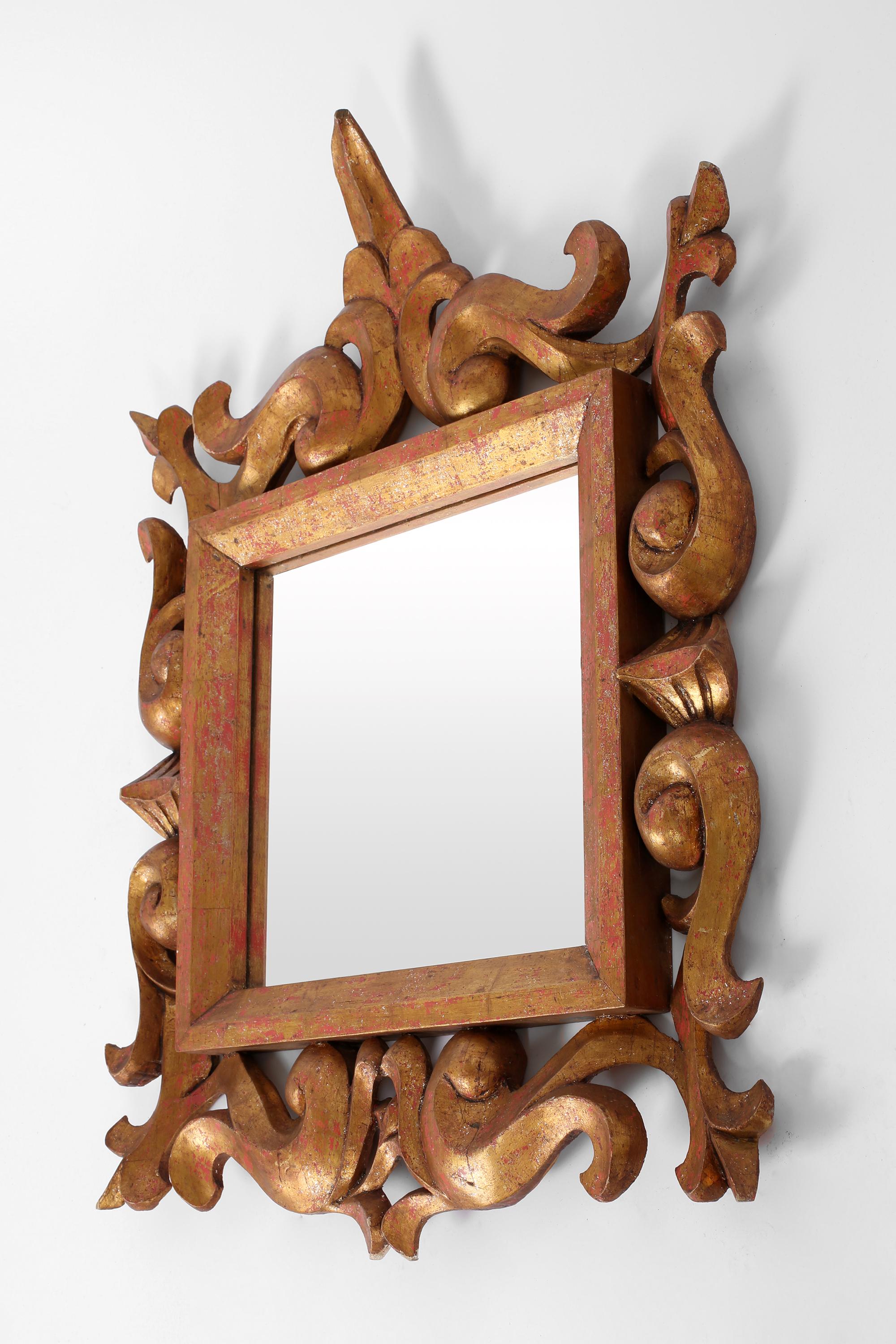 A statement hand-carved and gilt wood Florentine style mirror. French, c. 1940s.
