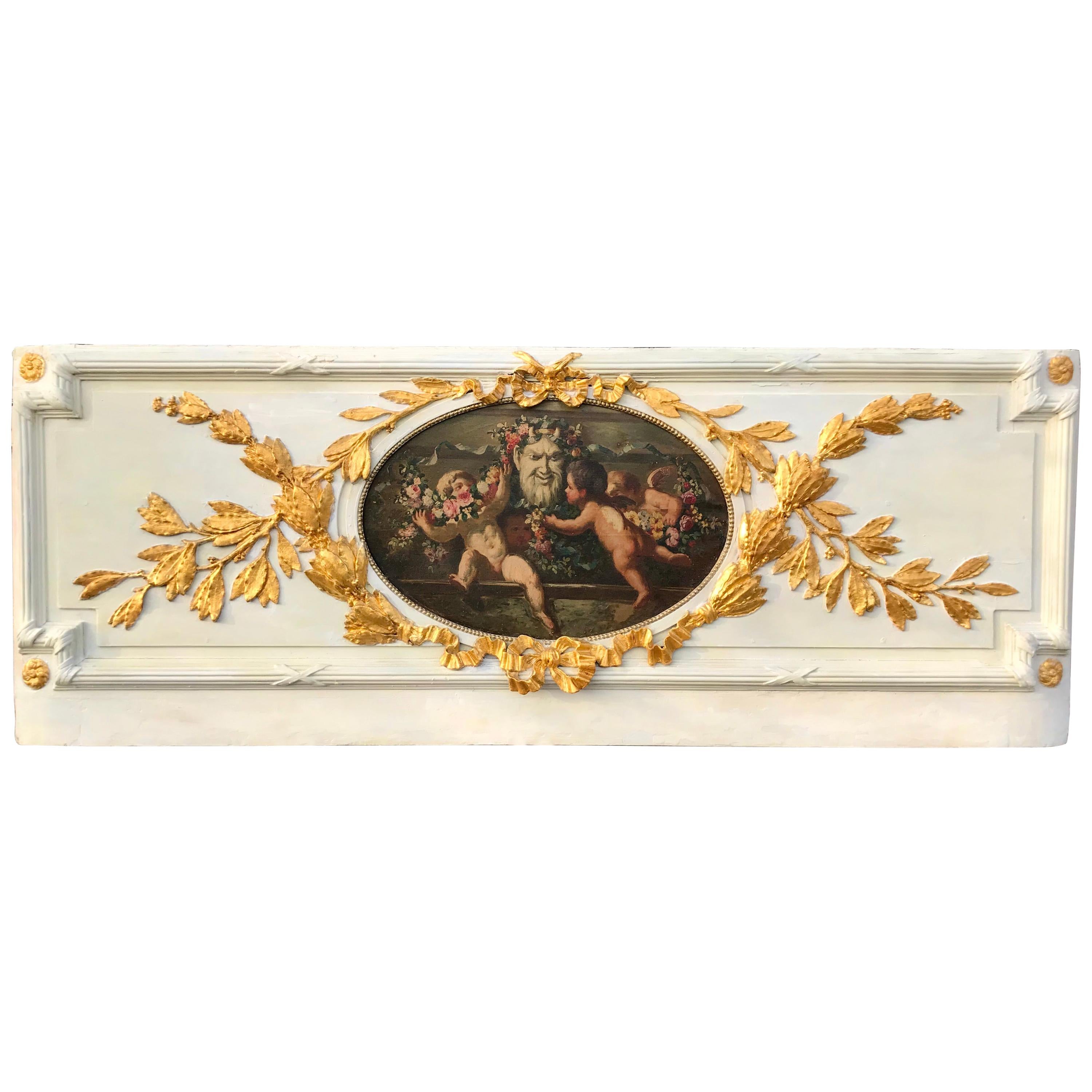 The architectural frieze fragment (Supra porta) removed from paneling. A decorated panel of Louis XVI style . The neoclassical styled panel with gilded leaf garland intertwined with ribbon surrounding a colorful oil inset of four cherubs or putti
