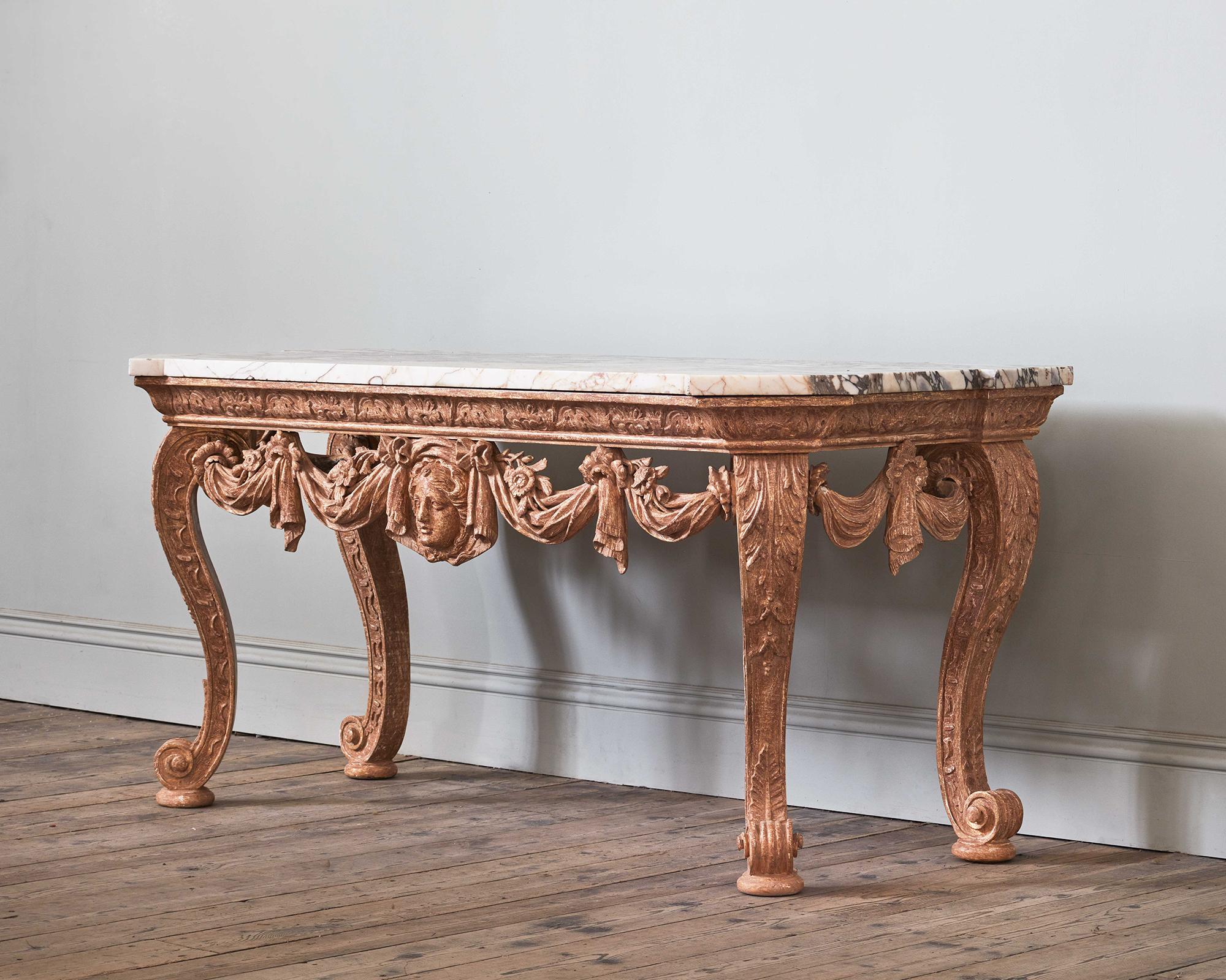An Impressive Mid 18th Century Carved Giltwood Console Table, in the manner of Kent

Carefully dry stripped to reveal the soft lustre of the original gilt surface, the table has exceptional carving to the shaped frieze, on wonderfully drawn cabriole