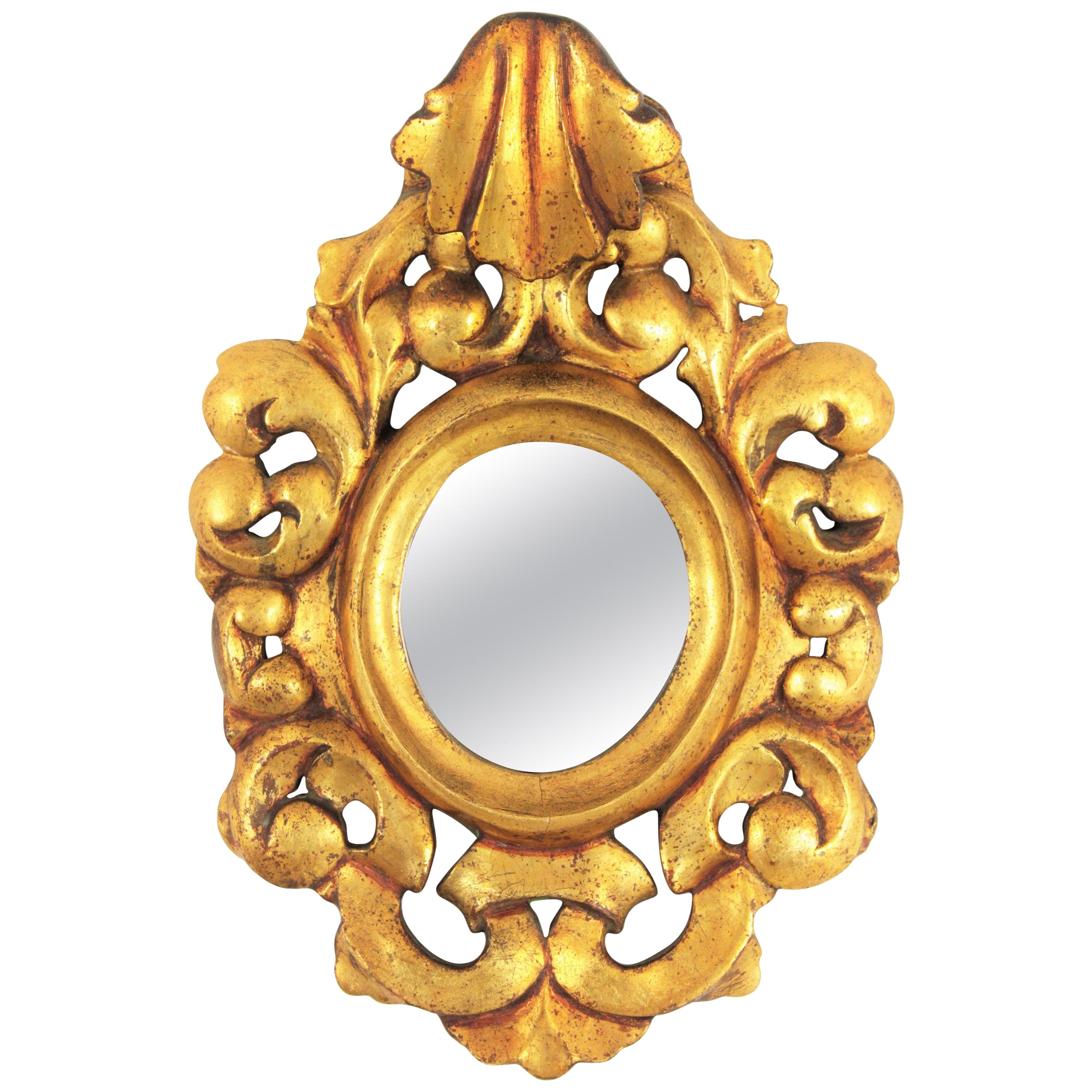 Rococo style mirror miniature with a carved giltwood frame and crest, Spain, 1940s.
A carved gold gilded frame surrounding an oval shaped glass and a beautiful crest adorning the top.
This mirror is a rare find due to its size.
It has been