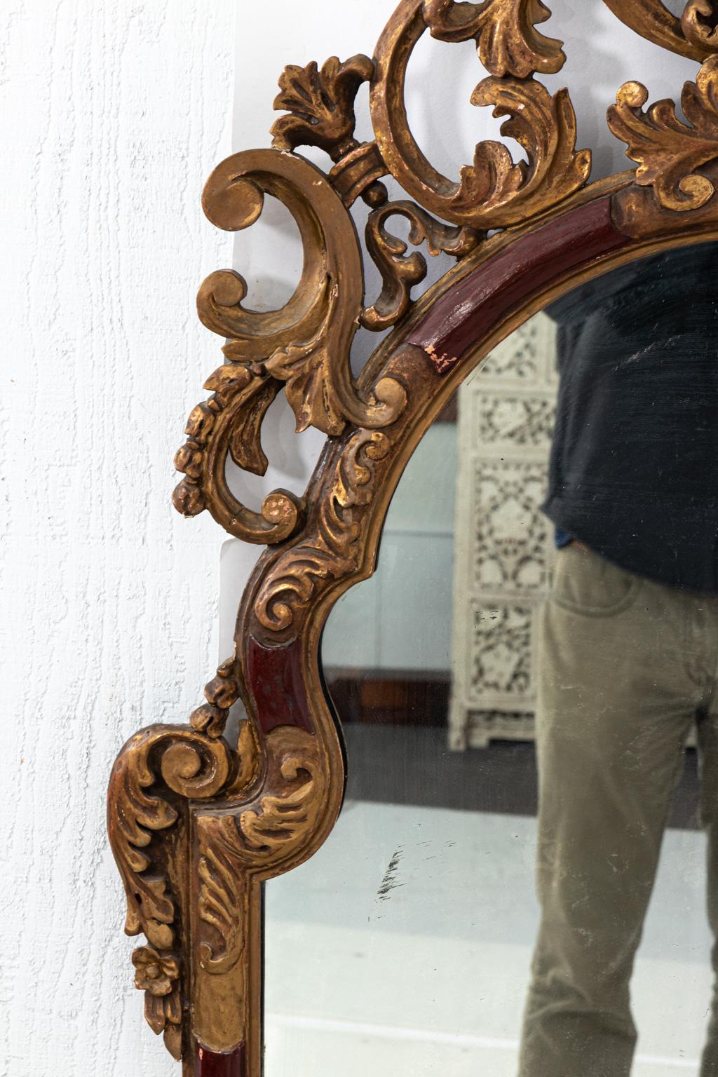 Gilt painted and carved mirror with scallop shell detail on the crown. Please note of wear consistent with age including gilt and finish loss to the mirror plate.