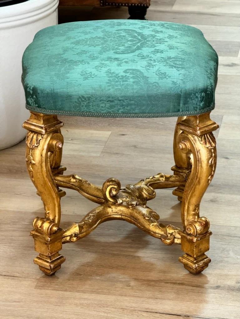 Exceptionnel tabouret en bois doré sculpté du XVIIIe siècle, avec siège en damas de soie d'époque, reposant sur des pieds à enroulement sculptés de feuilles et reliés par un châssis en X, probablement anglais, peut-être français.  

