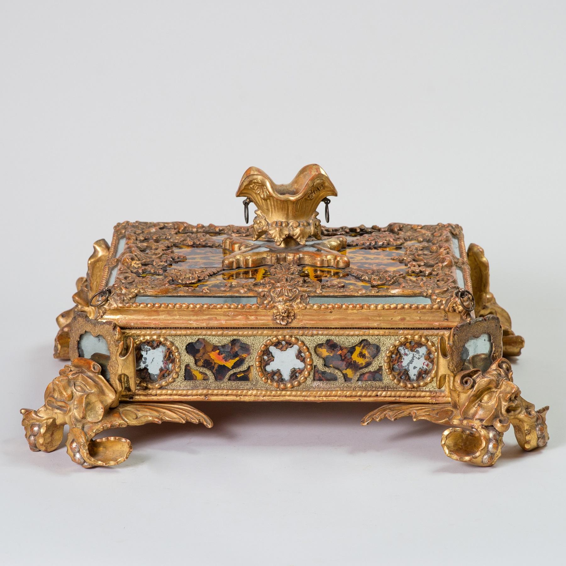 This extraordinary casket with its complex series of grotesque sea creatures, shells and star motifs echoes nautical mythology and the growing fashion for grottos.

Cracks to verre eglomise, refreshments to gilt and now lacking iron strapwork