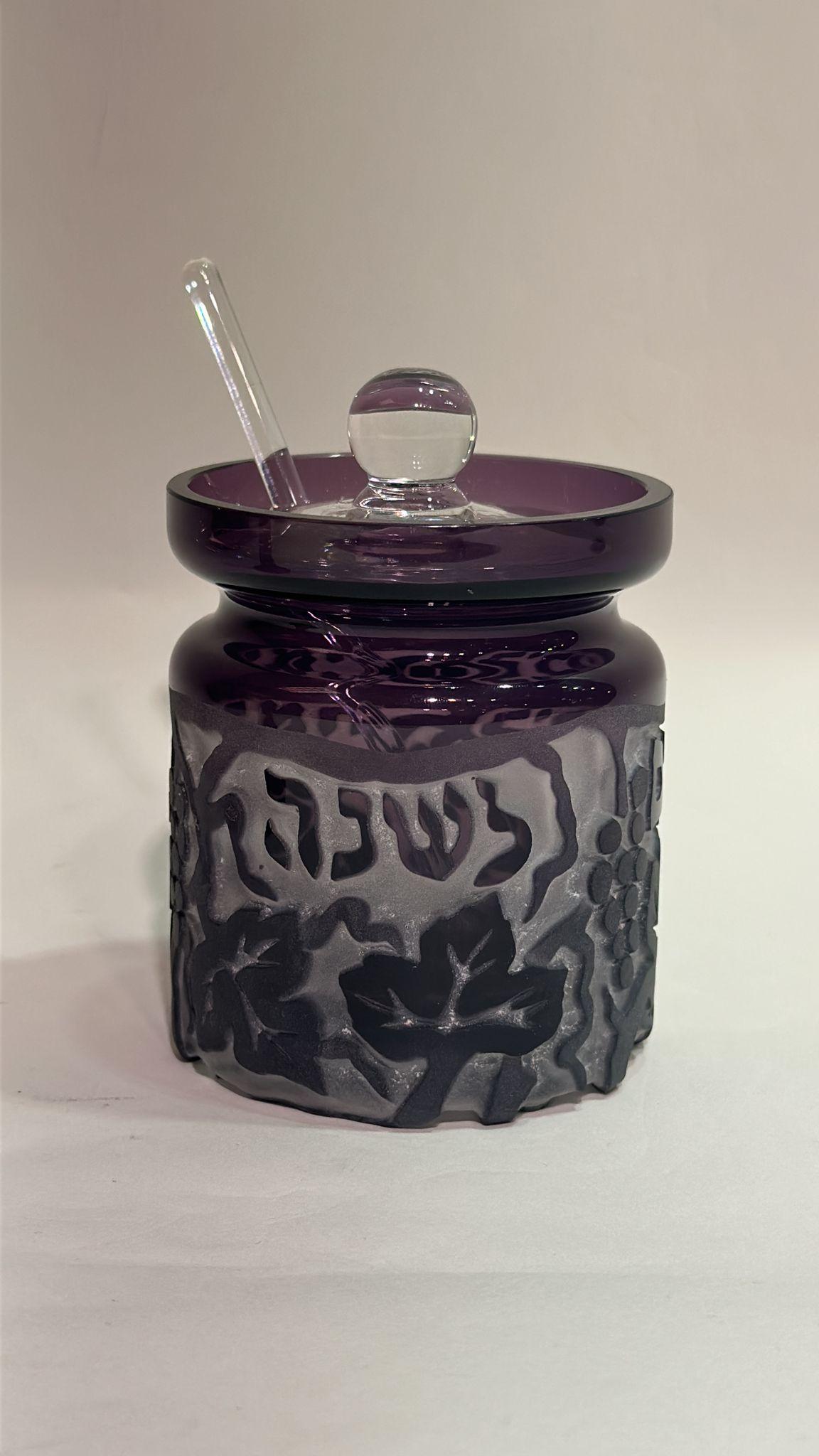 Este exquisito tarro de miel de cristal morado, obra de Steve Resnick, está diseñado para su uso durante Rosh Hashaná (el Año Nuevo judío). La inscripción hebrea esmerilada, 