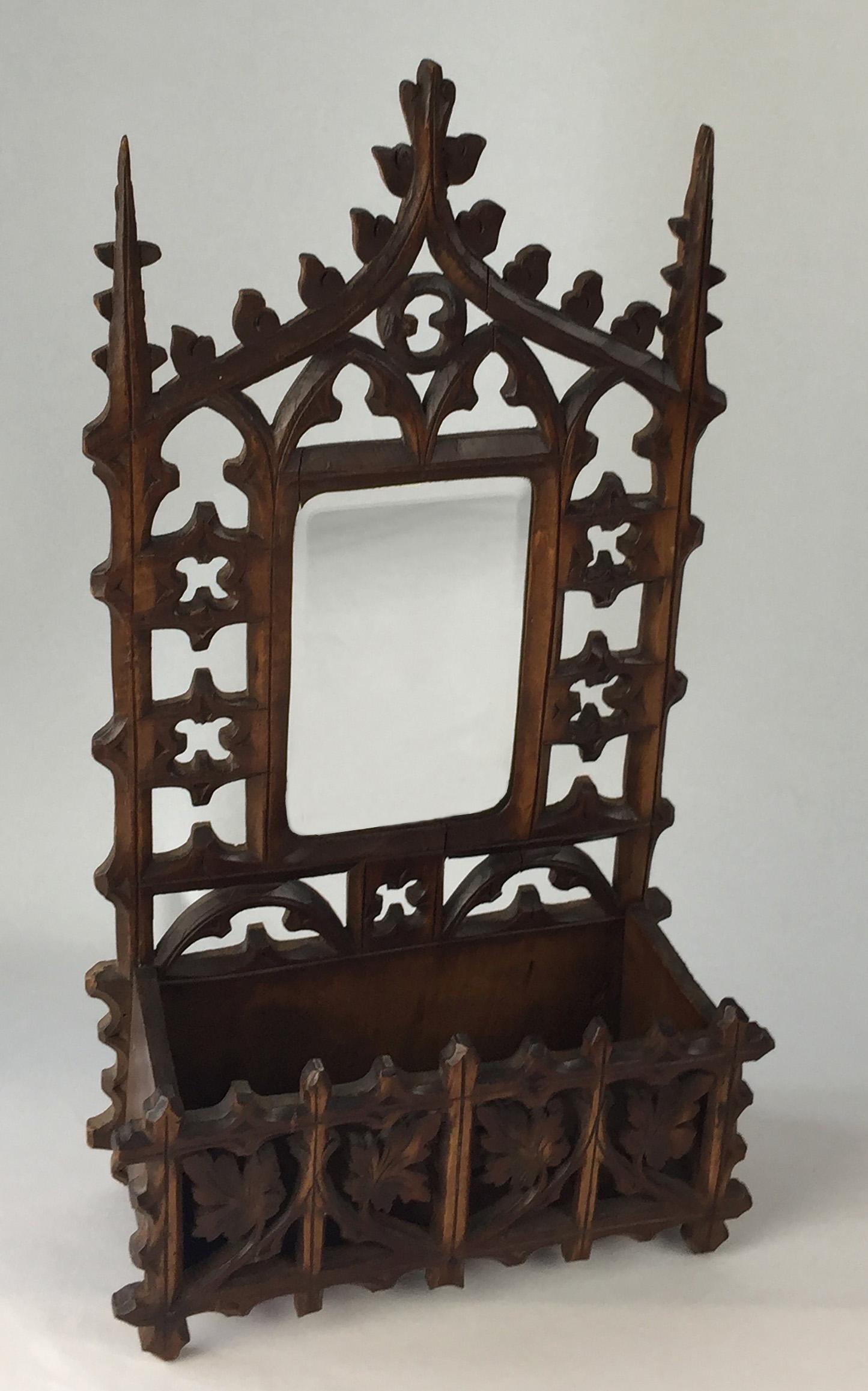 Carved wood fretwork letter rack with small box and bevelled curved cornered mirror. Could be storage for car keys or letters. Some damage. The wood could be lime wood as the carving is delicate.