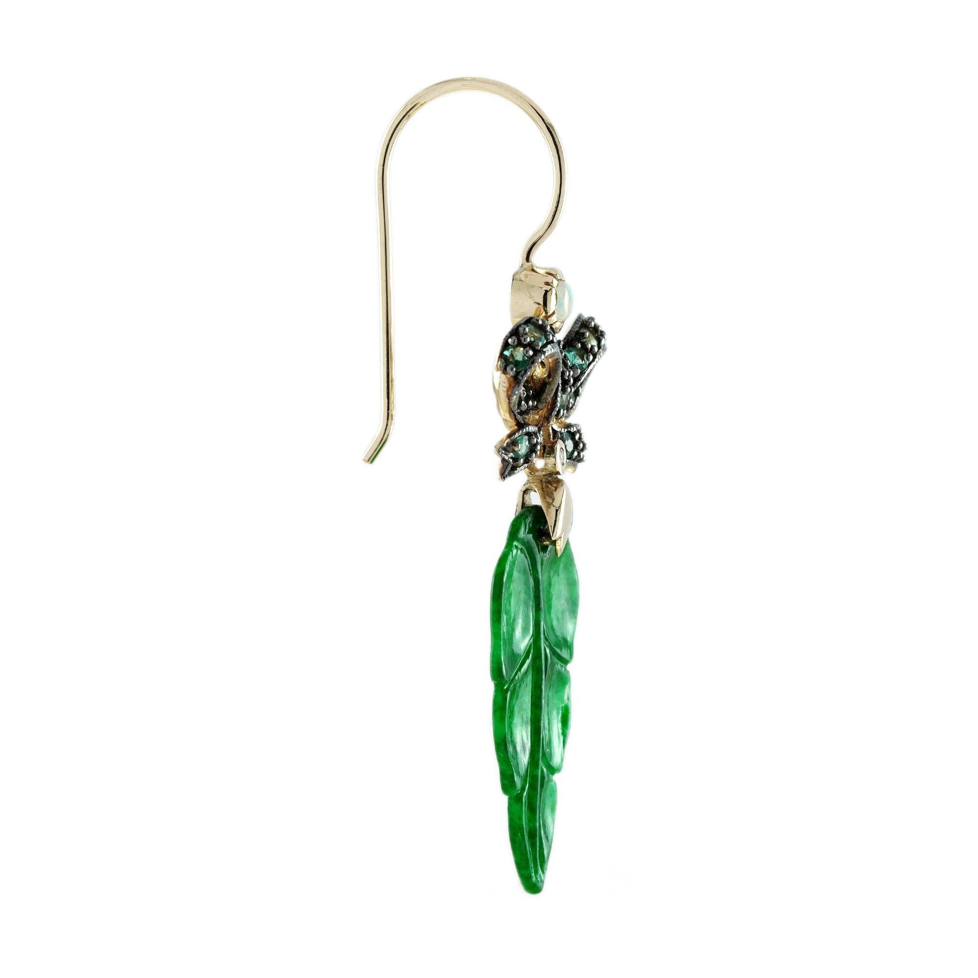 The natural jade in these lovely earrings has some very special shape. Both pieces have a strong green color and well leaf carvings. The jade is suspended in a 9k yellow gold setting with emerald ribbon bow on the top. The earrings transfer their