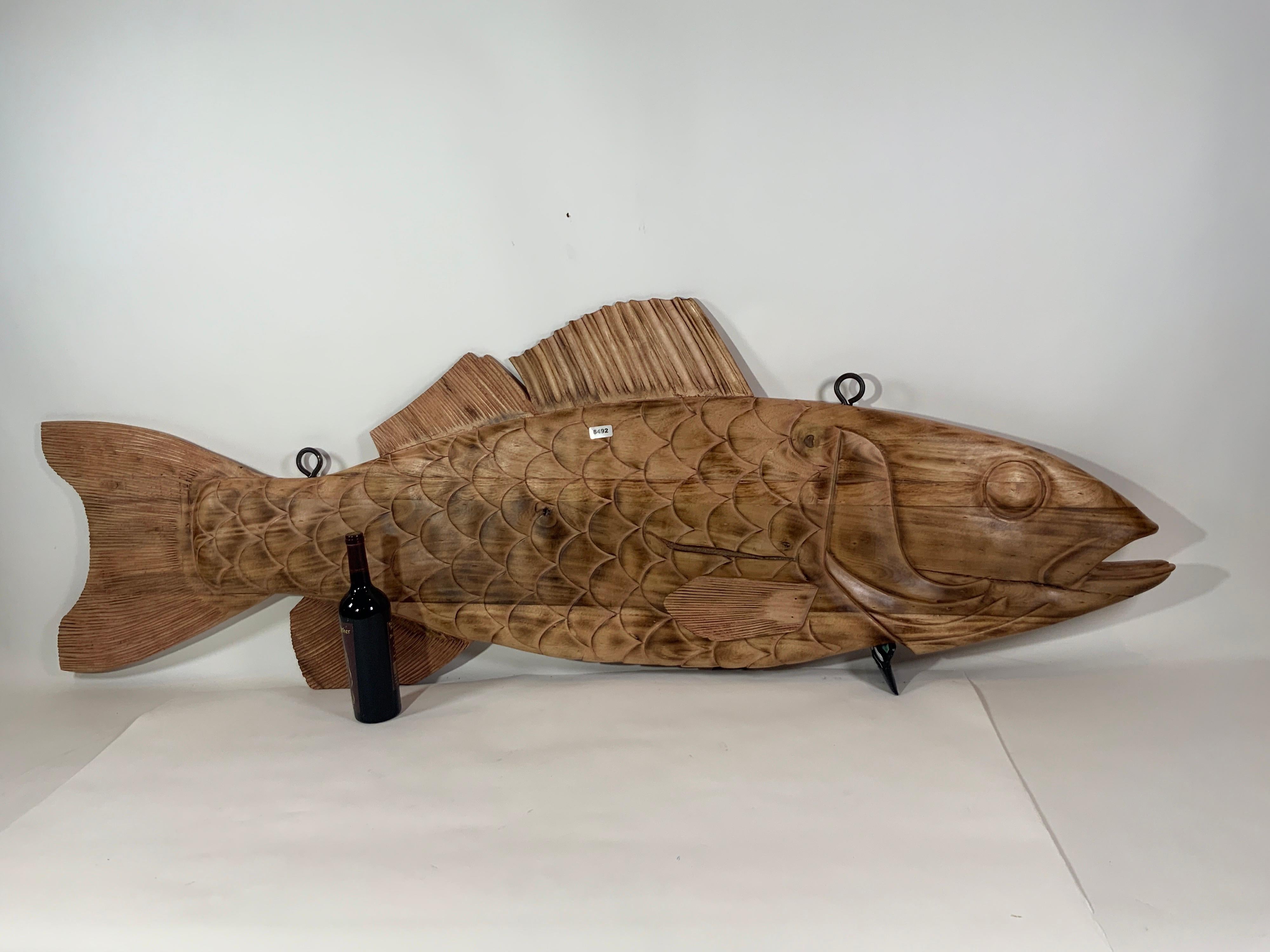 Six foot carved wood fish reminiscent of a nineteenth century trade sign. With carved gills, fins, scales, eyes and mouth. Fitted with iron hanging bolts, wax finish with flame accents.

Overall Dimensions: Weight is 45 pounds. 25