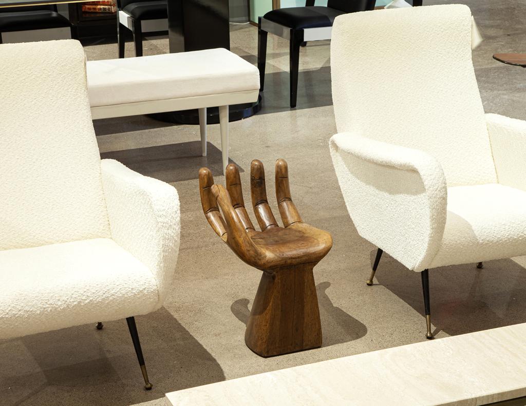 Adéntrate en lo surrealista con esta extraordinaria silla de mano, una obra maestra escultórica que evoca el estilo icónico de Pedro Friedeberg. Tallado en nogal, este asiento único transforma la forma familiar de una mano en una pieza de arte