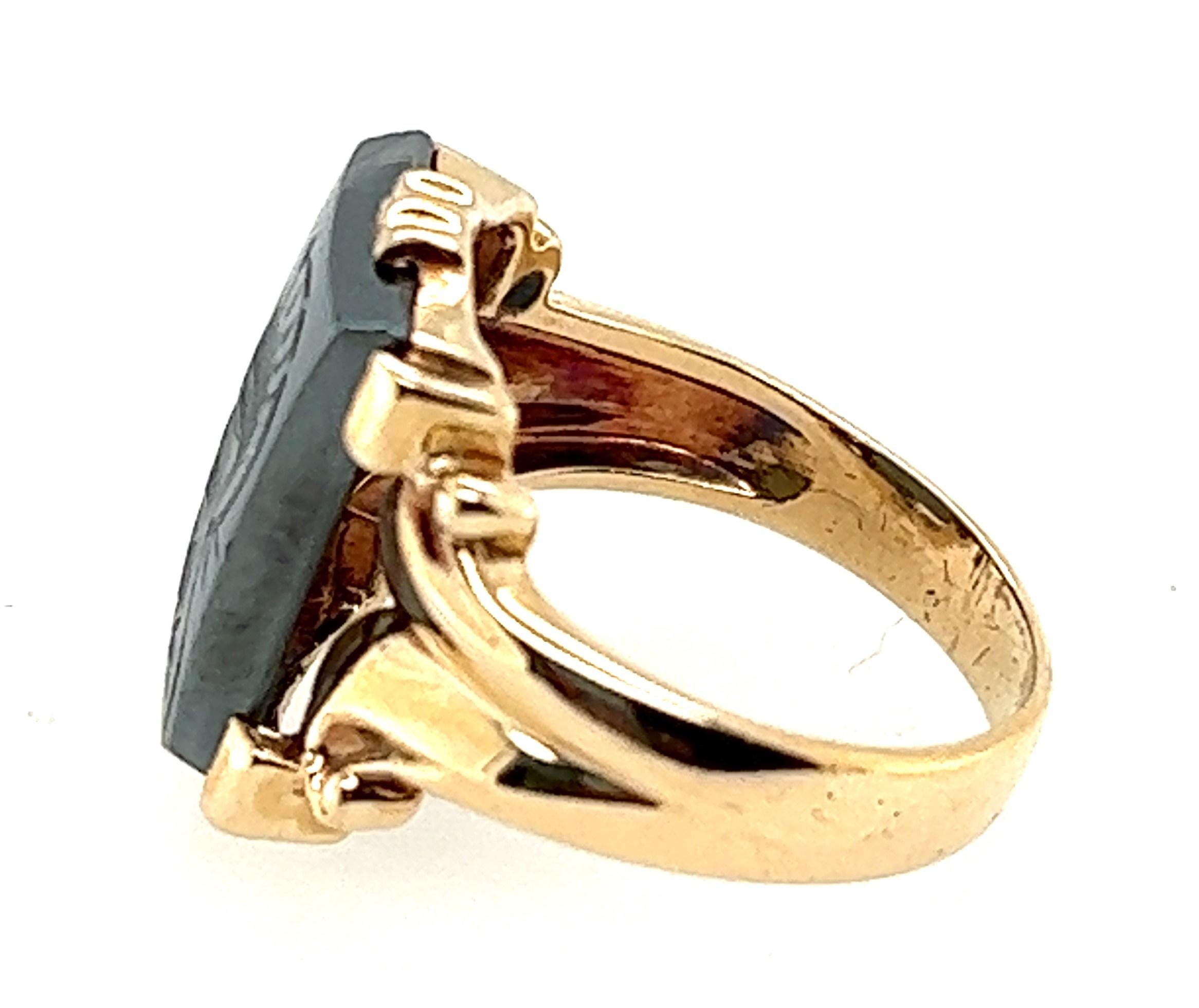 10KT yellow gold carved Intaglio Hematite ring. The carving is a helmeted soldier, 

The hematite measures 9/16 inches high by 7/16 inches wide. 

Finger size 8.75
