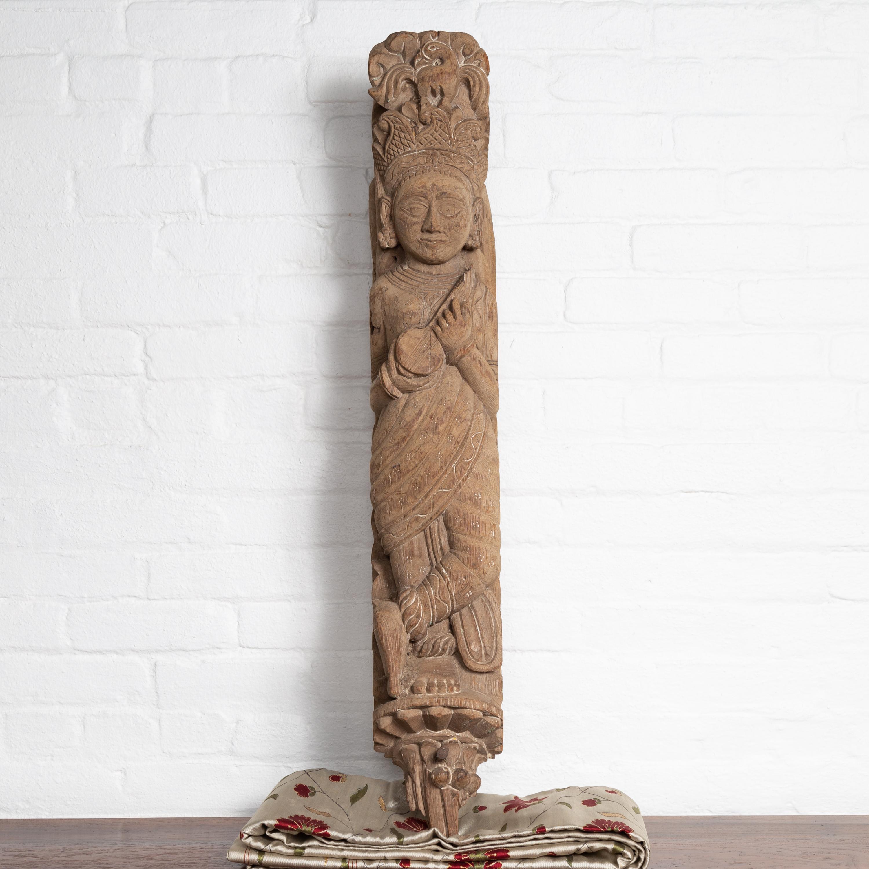 An antique hand carved Indian temple carving from Gujarat from the early 20th century, depicting a celestial musician. Born in the Western portion of India in the state of Gujarat, this exquisite hand carved temple sculpture features a female