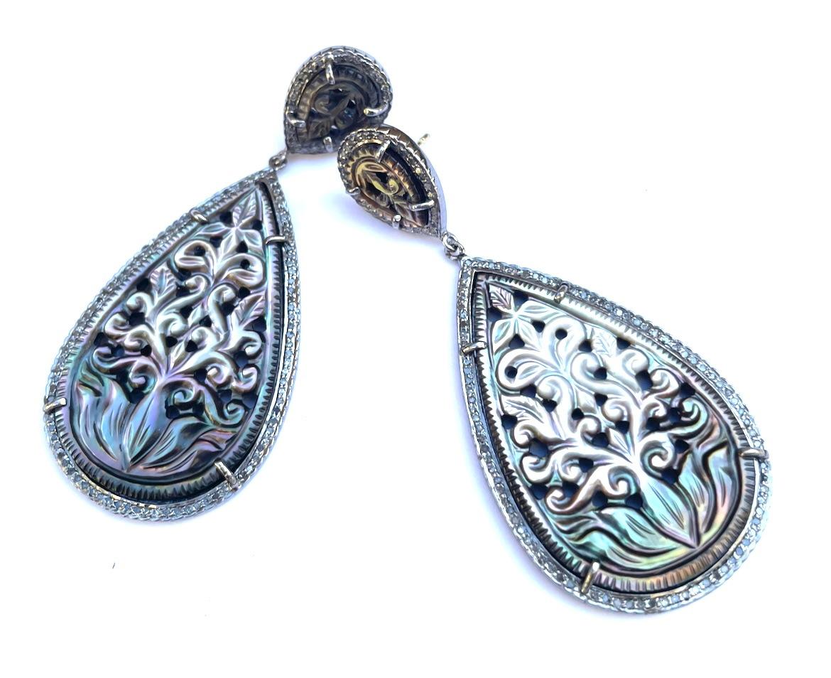 Description
Beautiful iridescent hand-carved Mother of Pearl earrings enhanced with pave diamonds, lovely for daytime as well as evening.
Item # E3264

Materials and Weight
Mother of Pearl, 30 x 48mm, pear shape, 84 carats.
Pave diamonds, 1.45