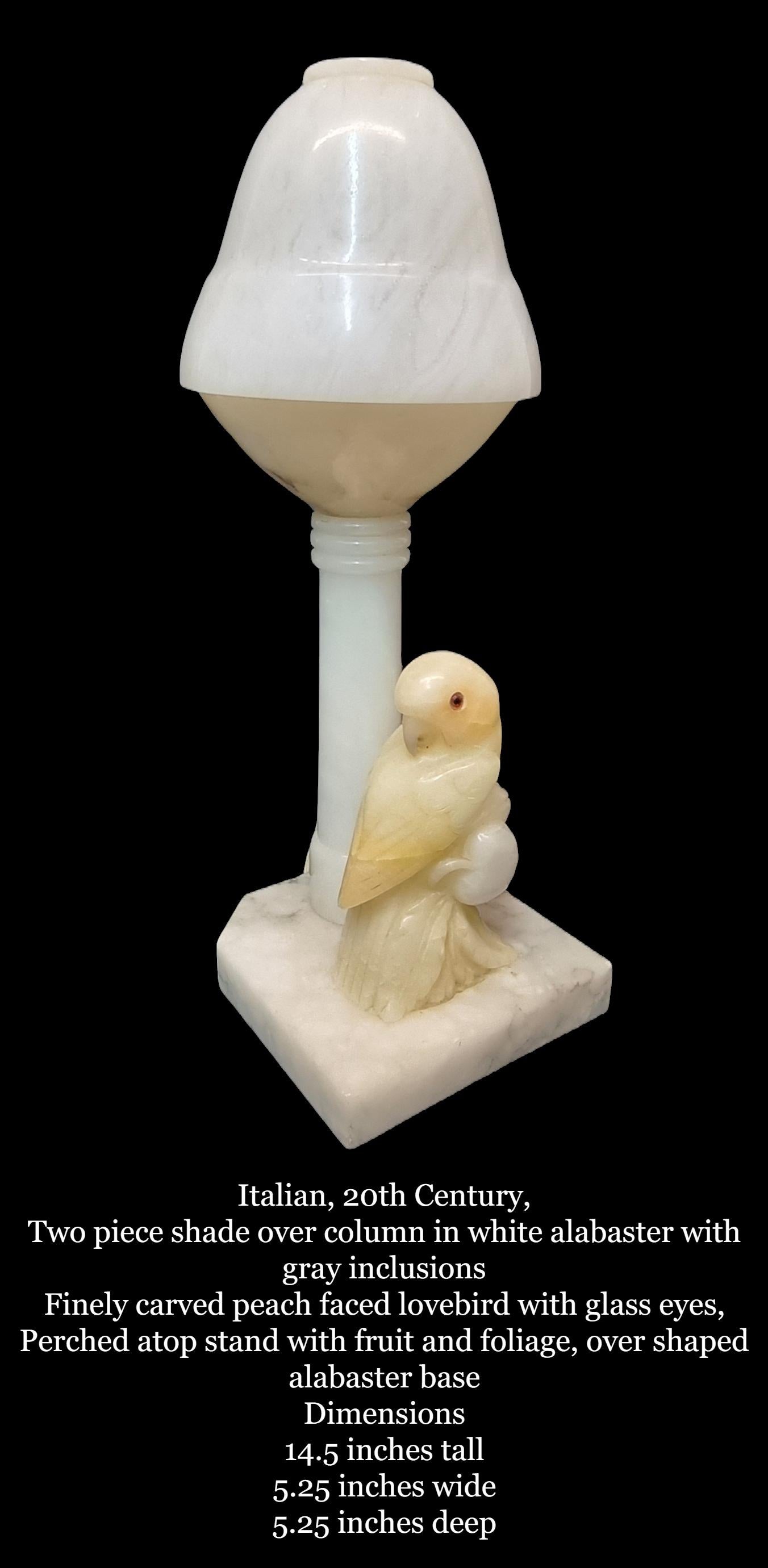 Carved Italian Alabaster Lovebird Table Lamp Italian, 20th Century

Two piece shade over column in white alabaster with gray inclusions
Finely carved peach faced lovebird with glass eyes,
Perched atop stand with fruit and foliage, over shaped